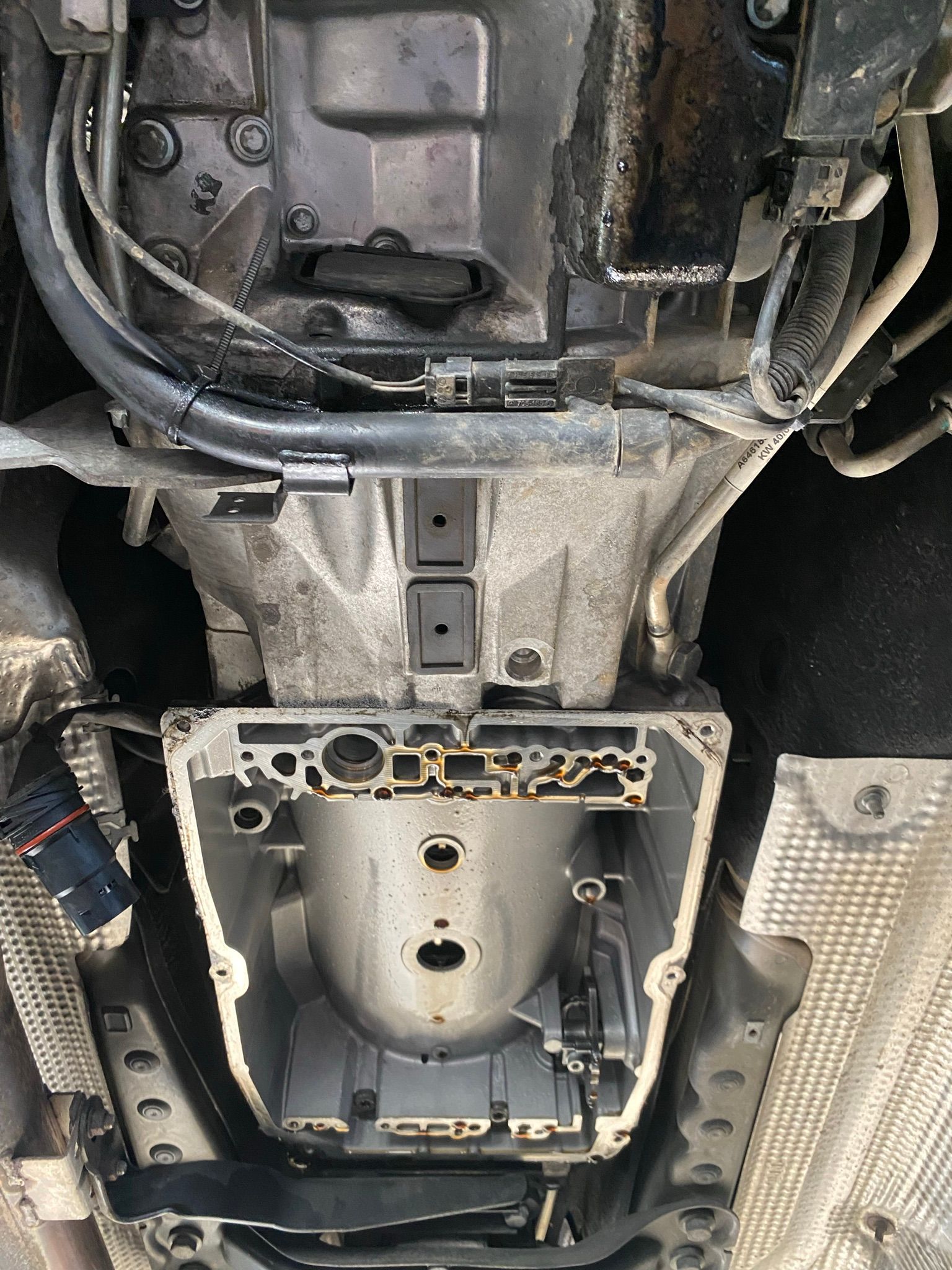 Un gros plan du dessous d’une voiture avec la transmission retirée.