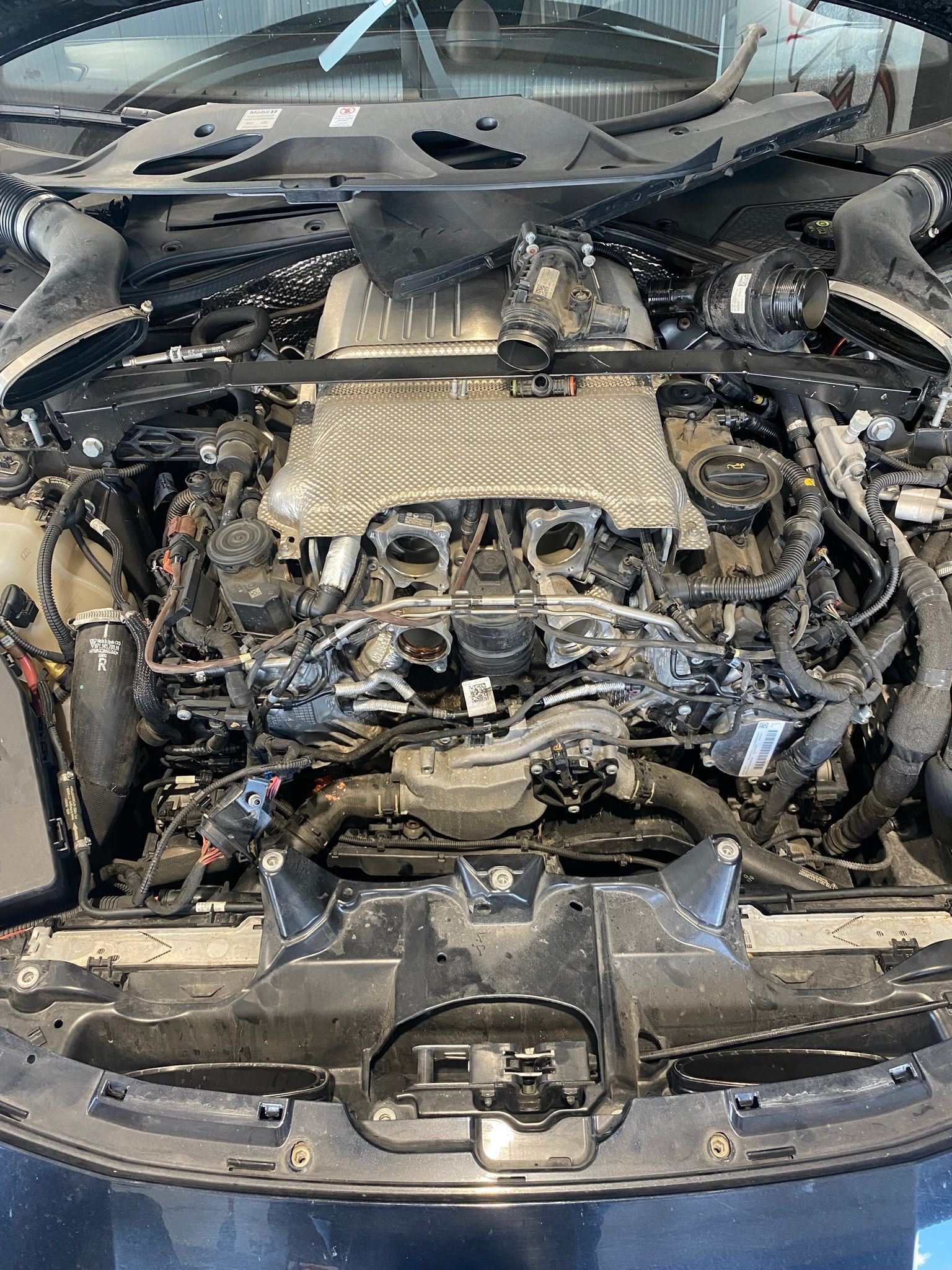 Un gros plan d'un moteur de voiture avec le capot ouvert.