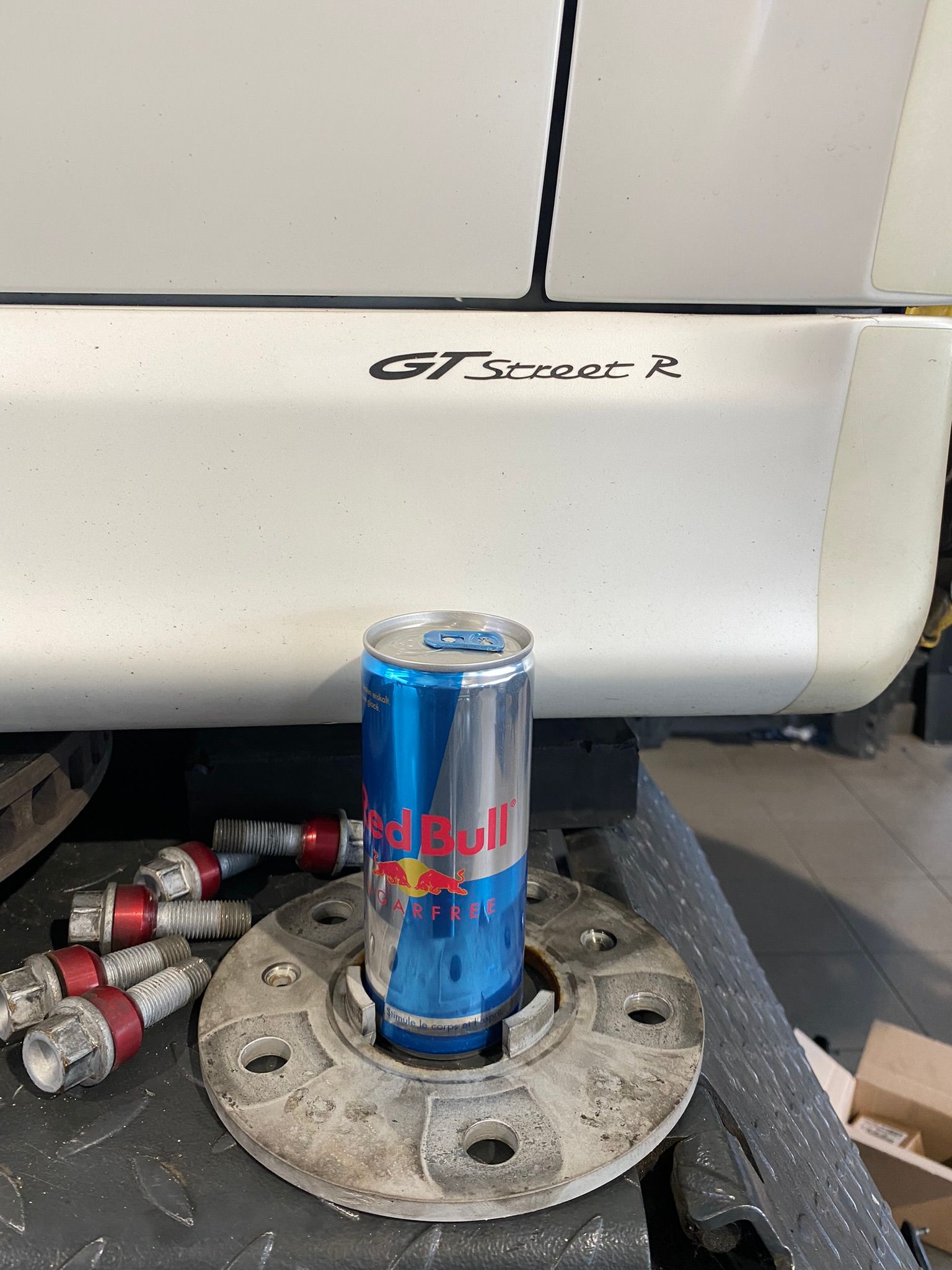 Une canette de Red Bull est posée sur un moyeu de roue.