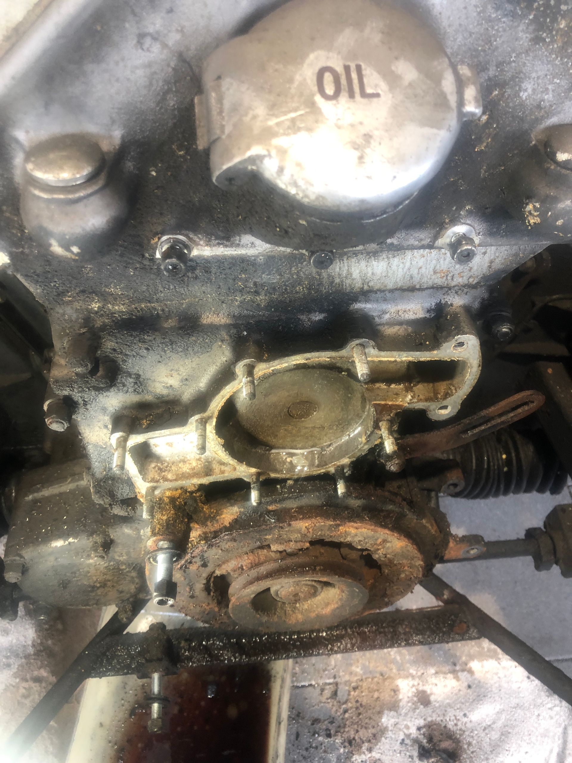 Un gros plan d'un moteur de moto avec le bouchon d'huile ouvert.