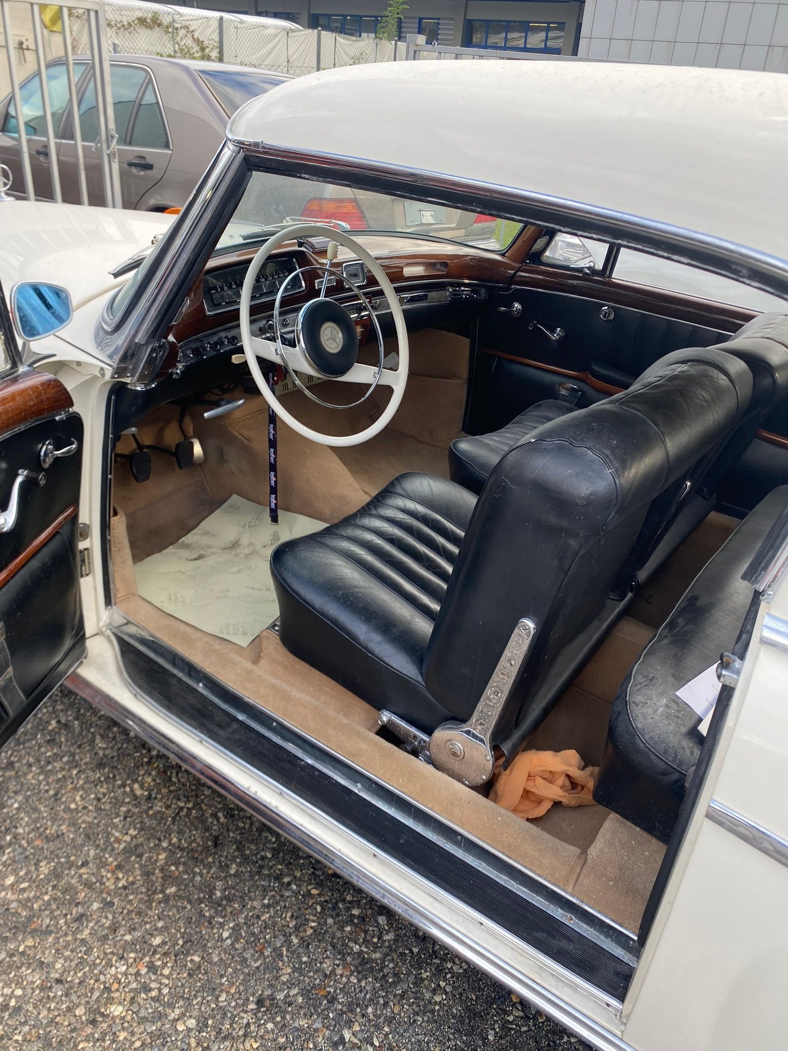 L’intérieur d’une voiture blanche avec la porte ouverte et le volant visible.