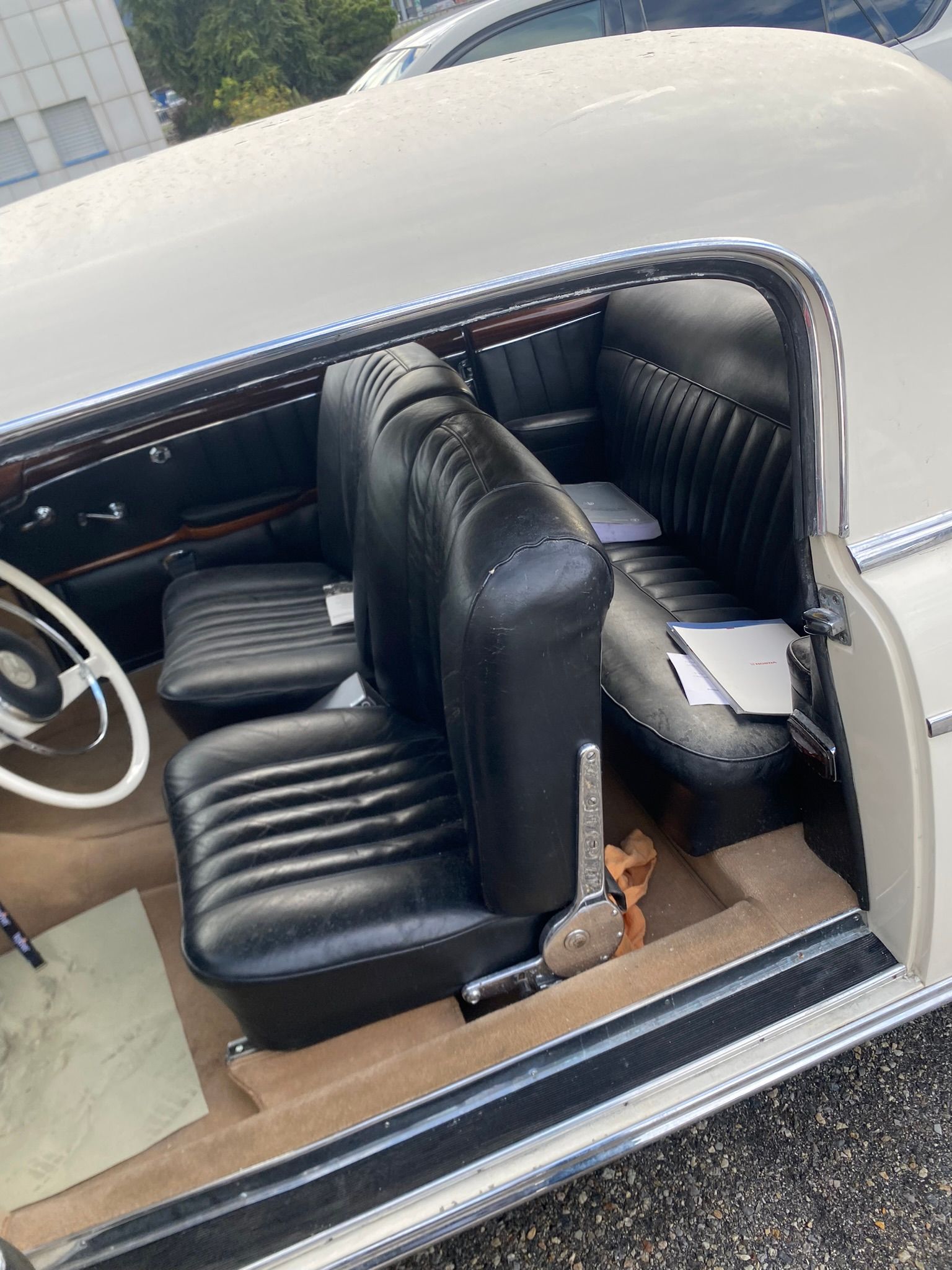 L’intérieur d’une voiture blanche avec des sièges noirs et un volant.