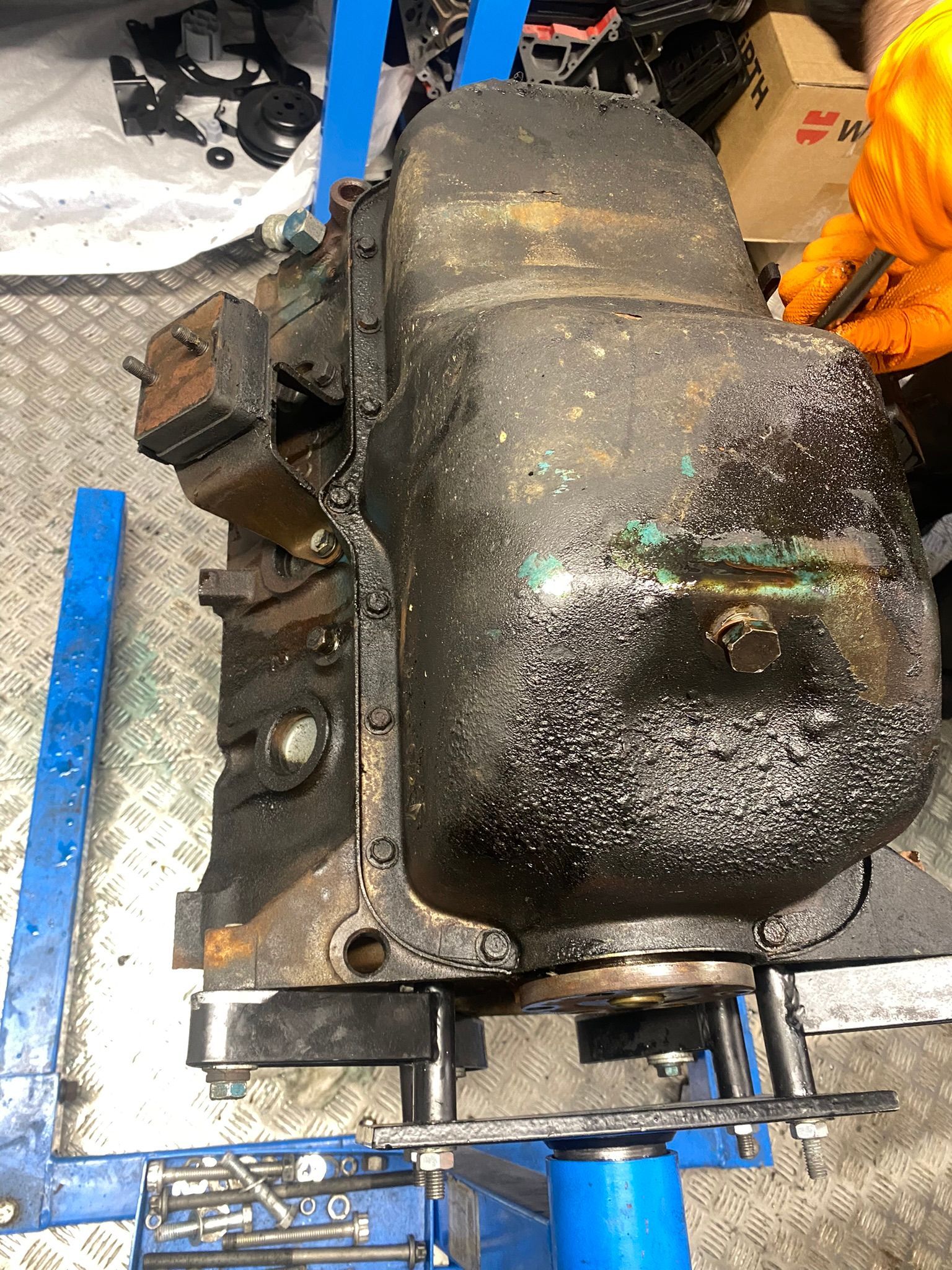 Un moteur sale est posé sur un support bleu.