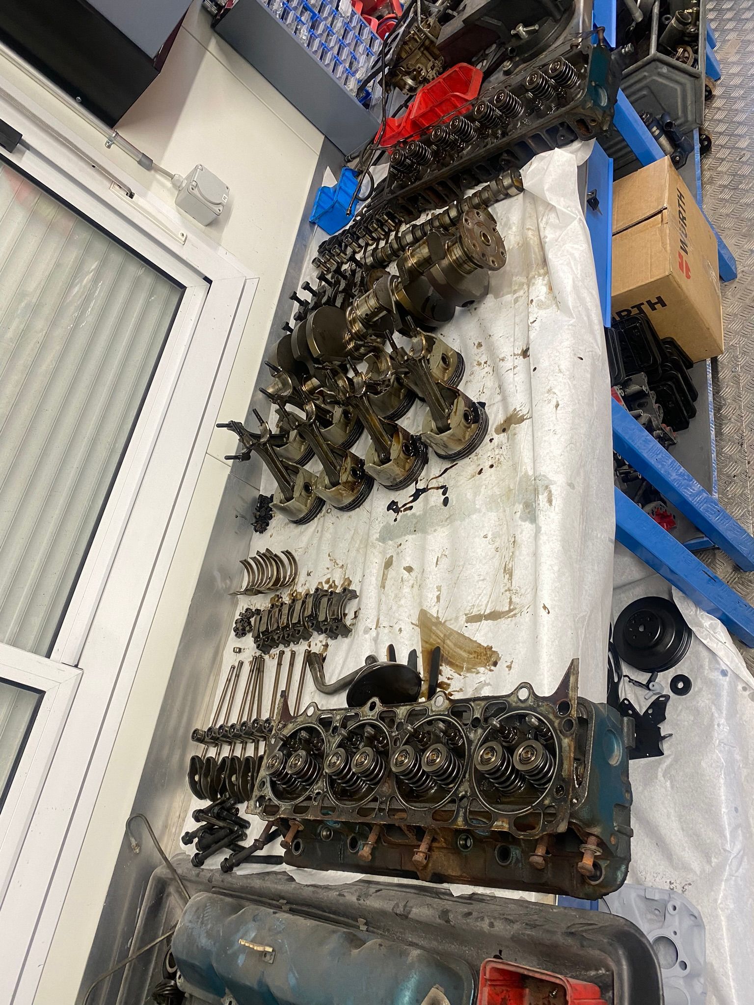 Un tas de pièces de moteur sont posées sur une table.