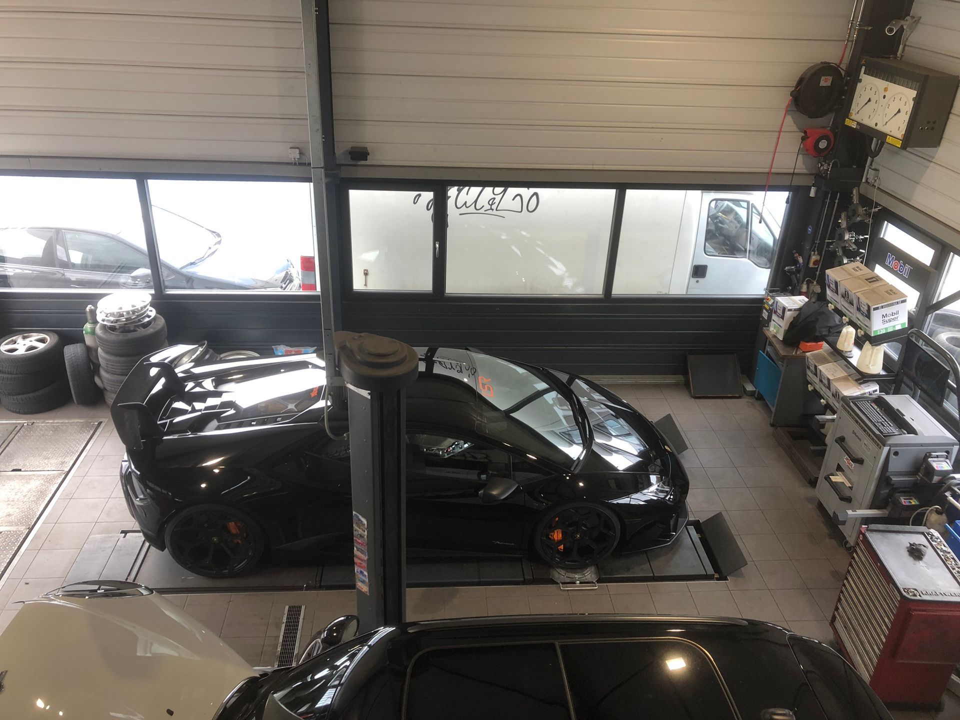 Une voiture est posée sur un ascenseur dans un garage.