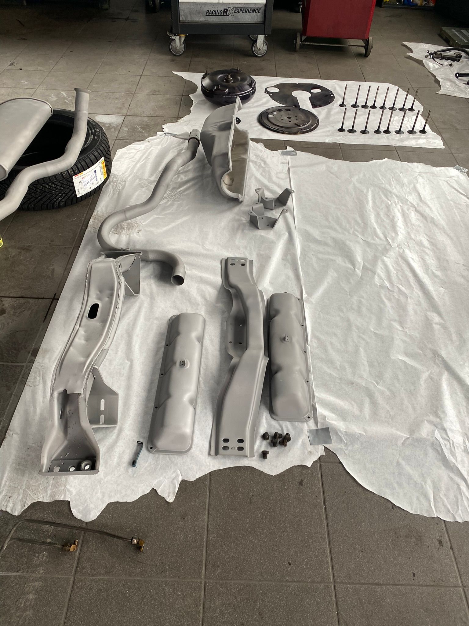 Un tas de pièces sont posées sur un tissu blanc au sol.