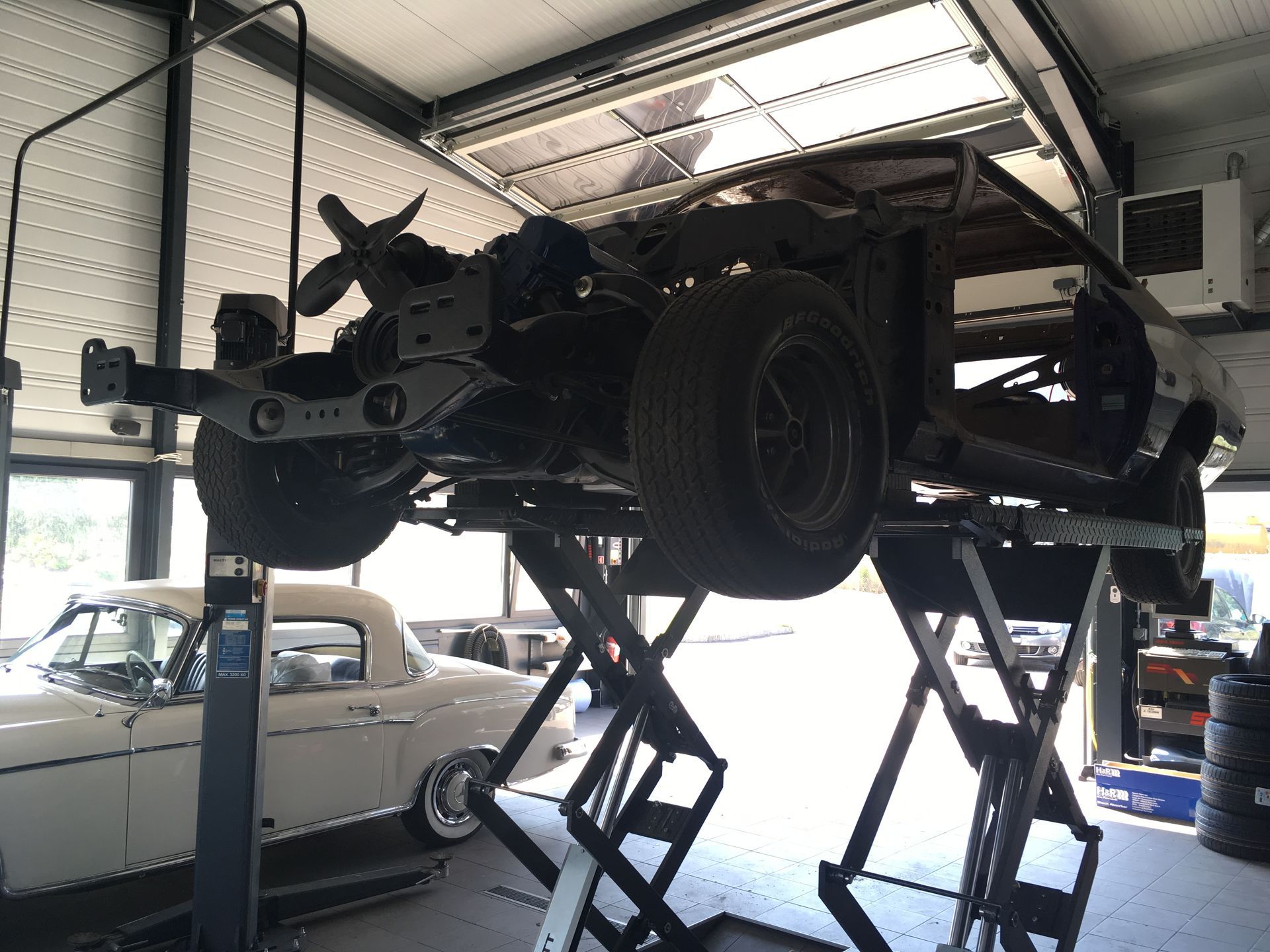 Une voiture est assise sur un ascenseur dans un garage