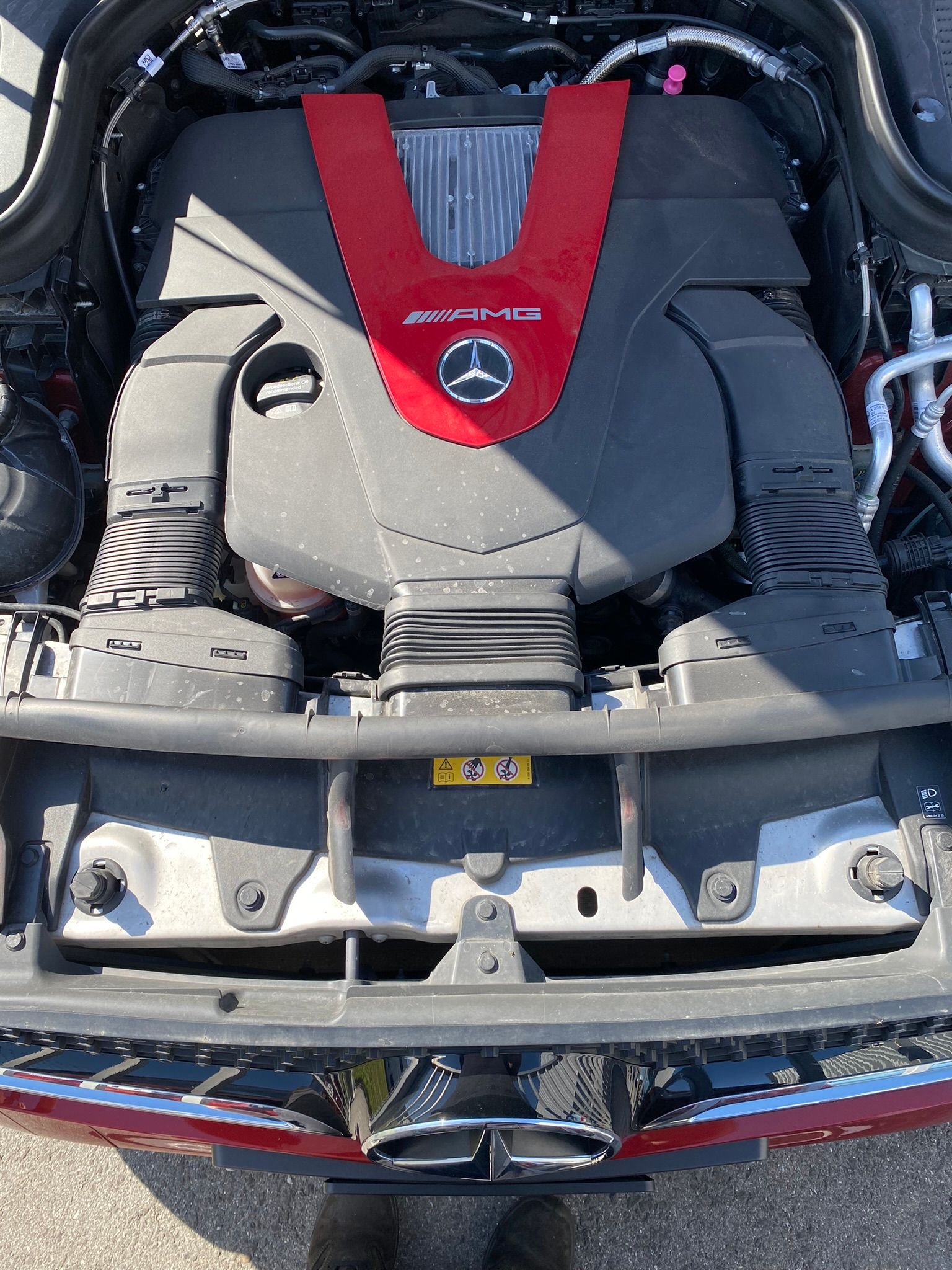 Le moteur d’une Mercedes Benz est représenté avec le capot ouvert.