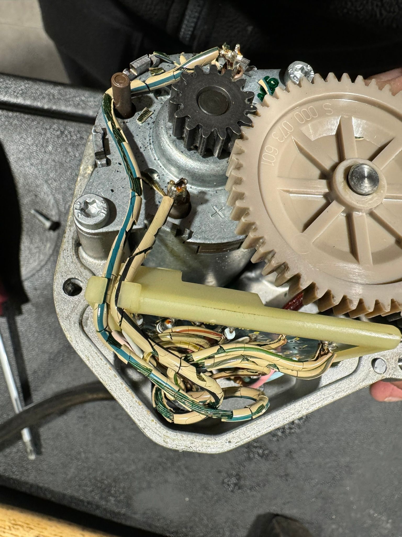 Un gros plan d'un engrenage sur une machine avec un tournevis.