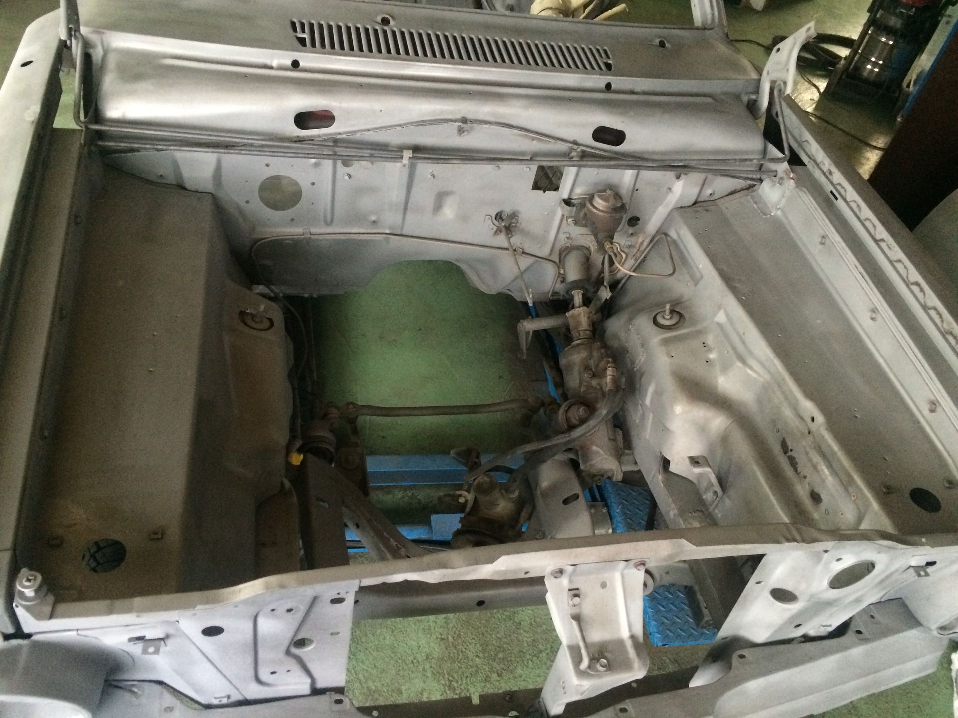 Le compartiment moteur d’une voiture est représenté avec le capot ouvert.