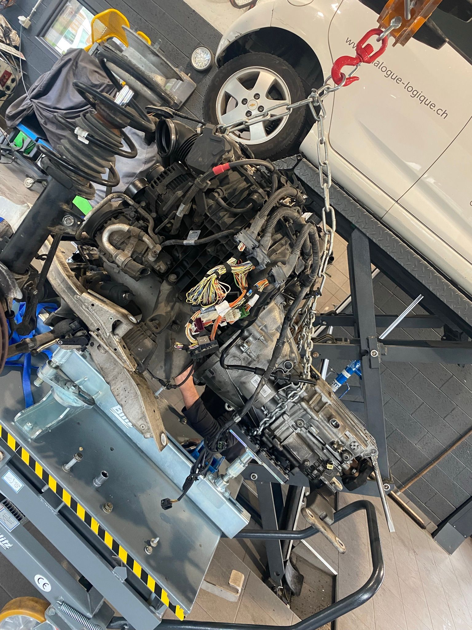 Une voiture est en cours de démontage dans un garage.