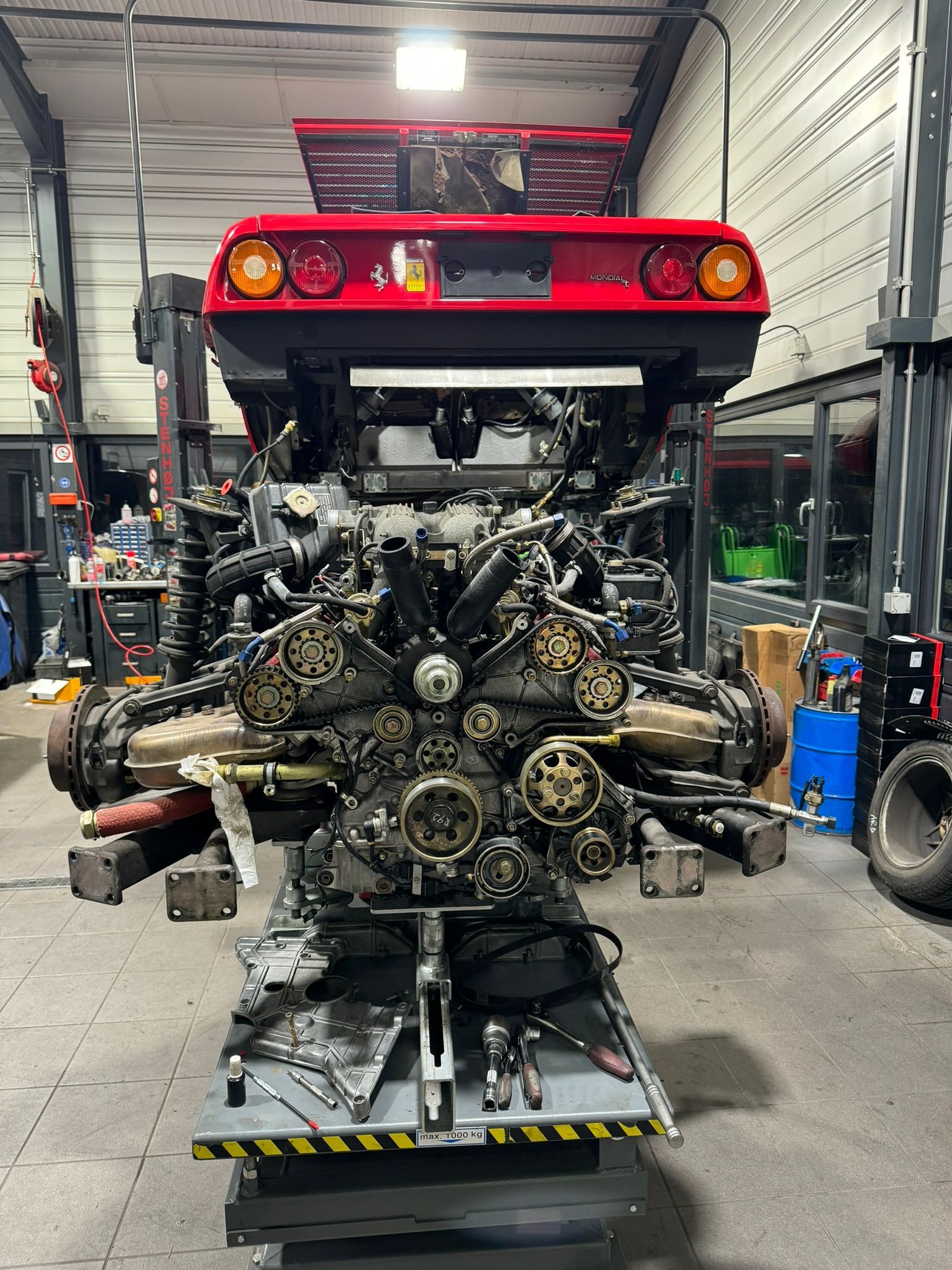 Un moteur Ferrari est en cours de préparation dans un garage.