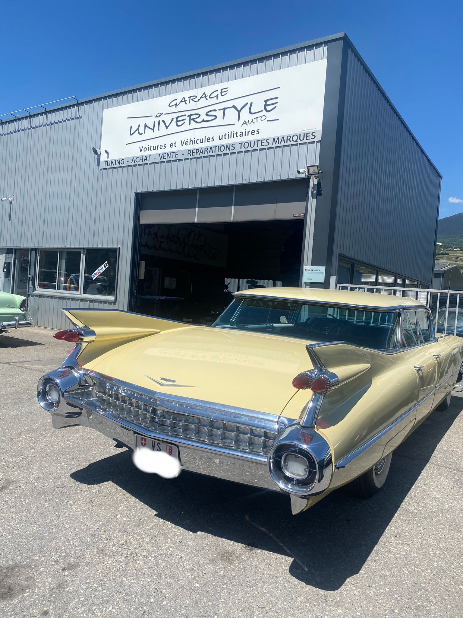 Une voiture jaune est garée devant un immeuble.