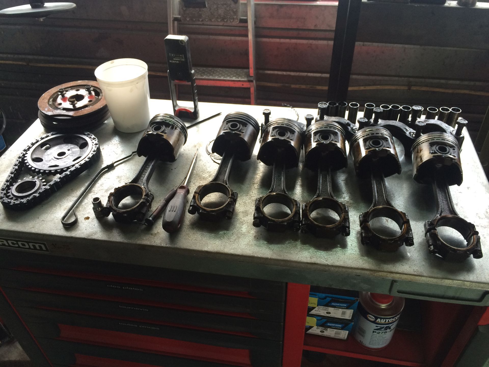 Une table avec un tas de pistons et d'outils dessus