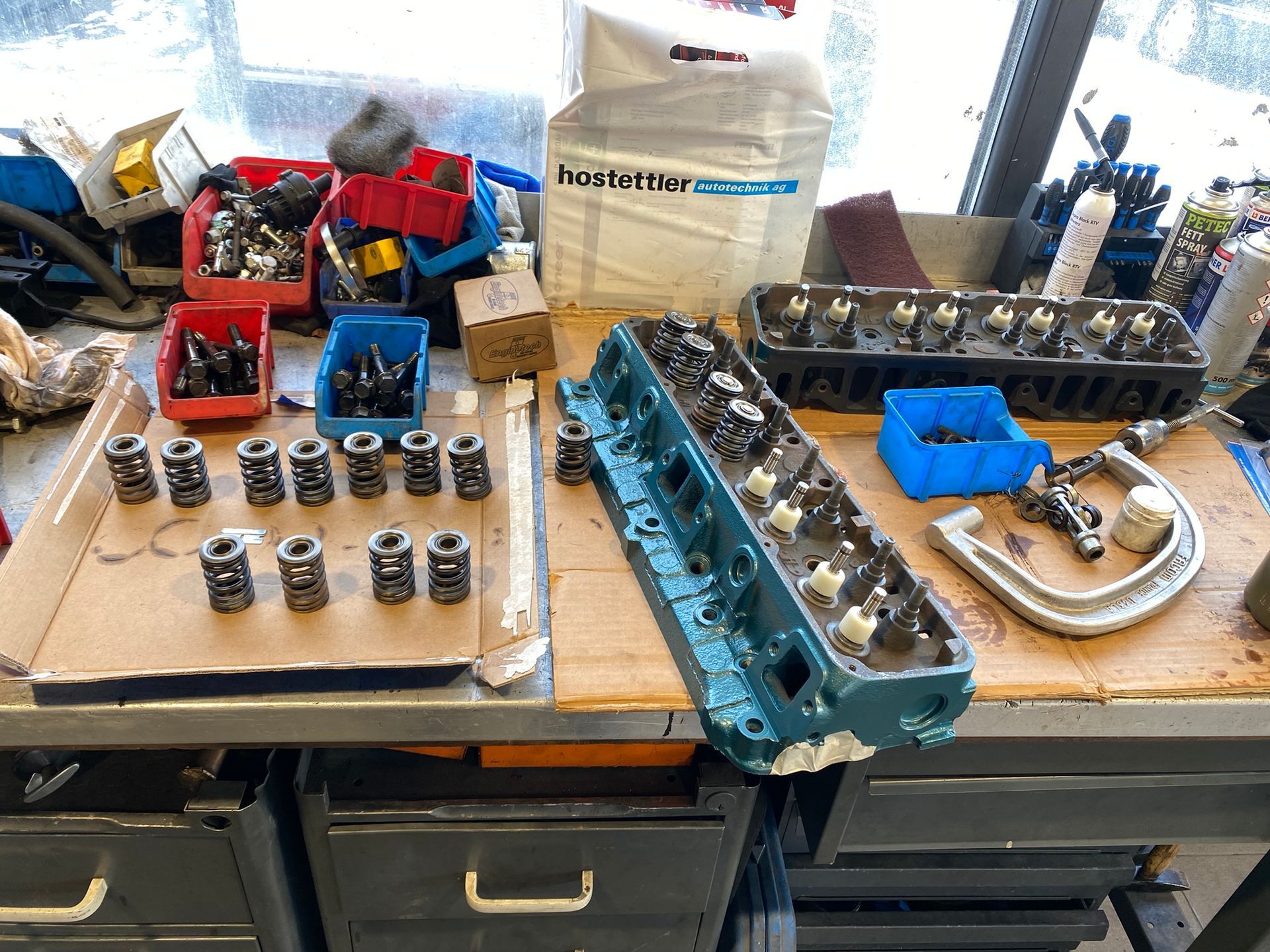 Une table avec un tas d'outils et une culasse dessus.