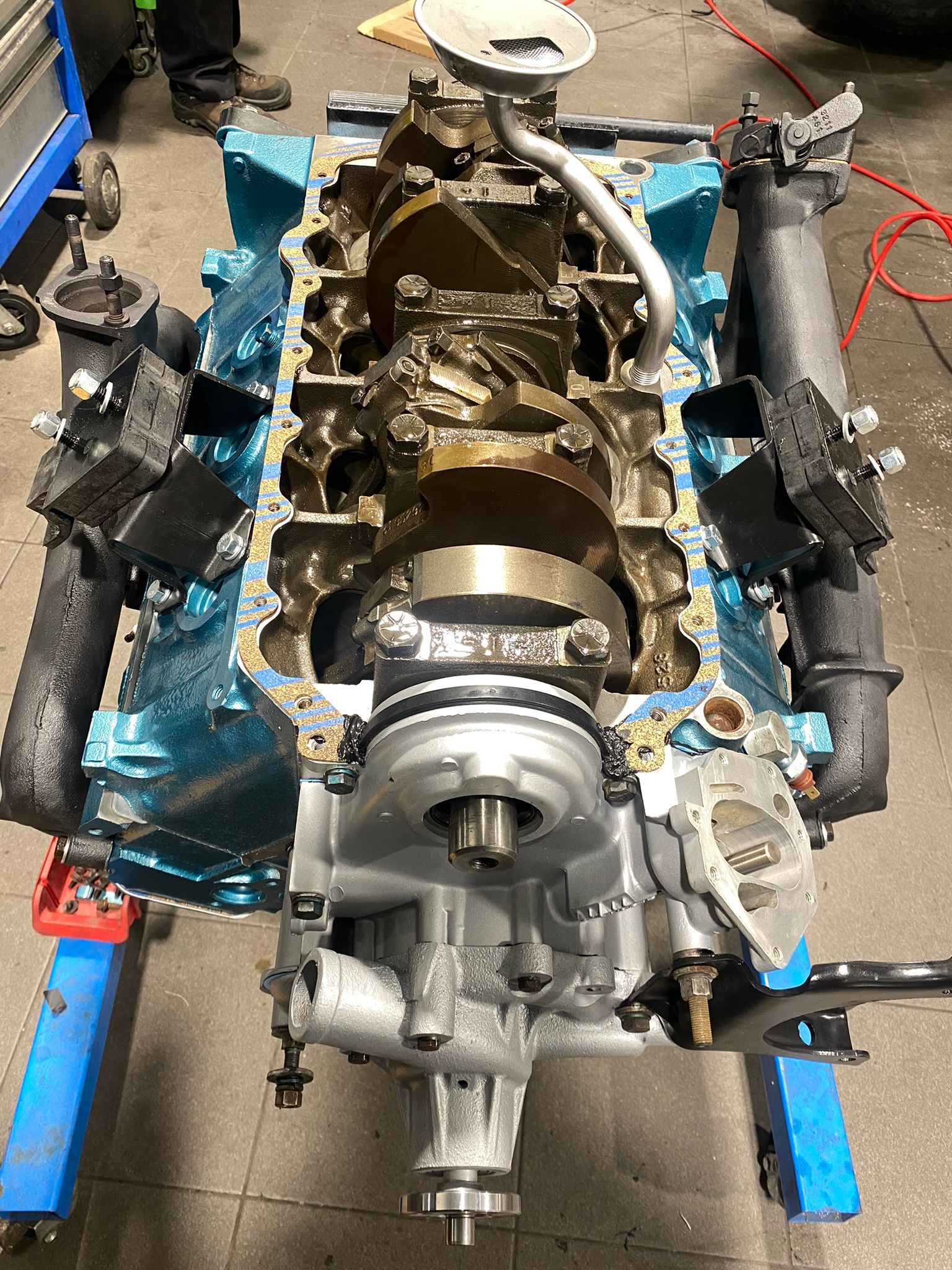 Un gros plan d’un moteur de voiture posé sur un support bleu.