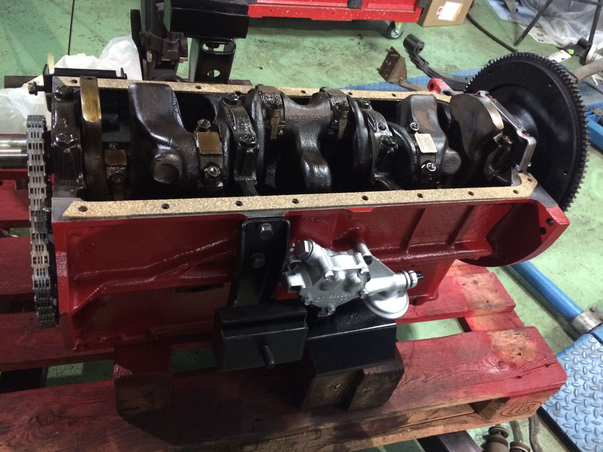 Un moteur rouge est posé sur une palette en bois