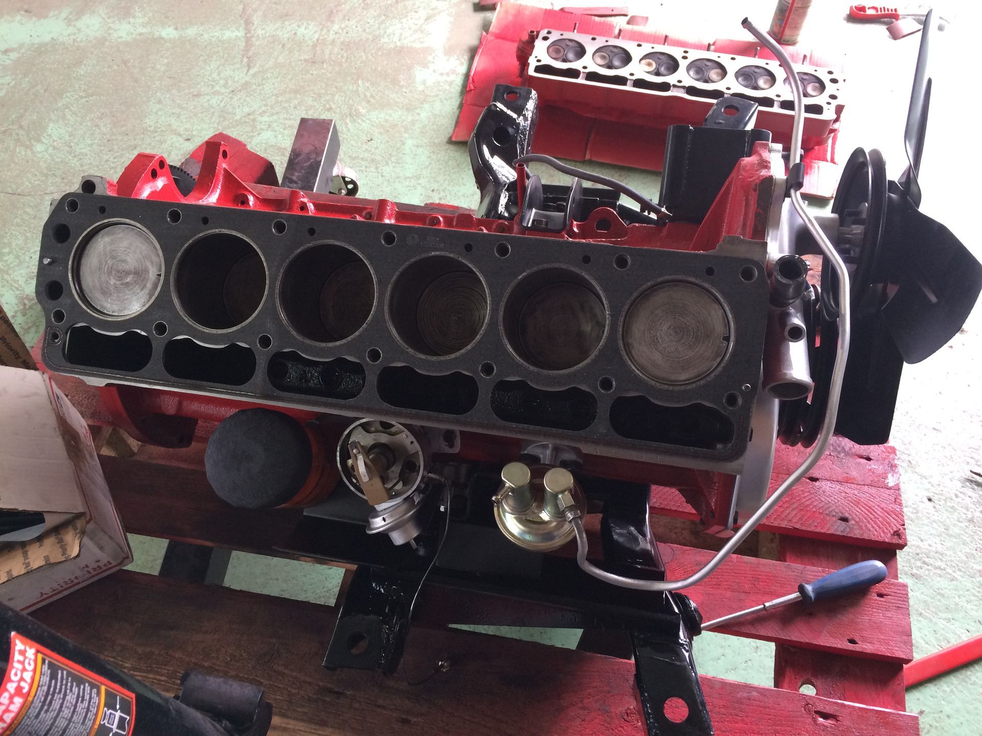 Un moteur rouge est posé sur une palette en bois