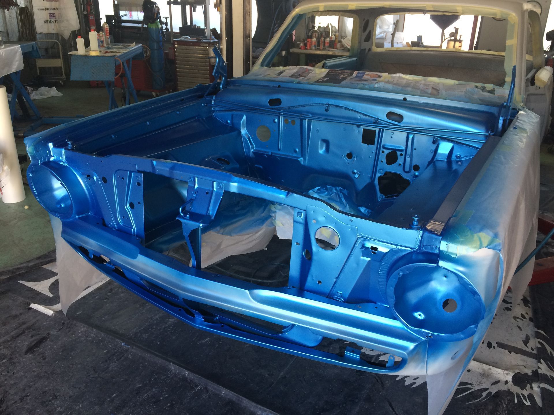 Une voiture bleue est peinte dans un garage