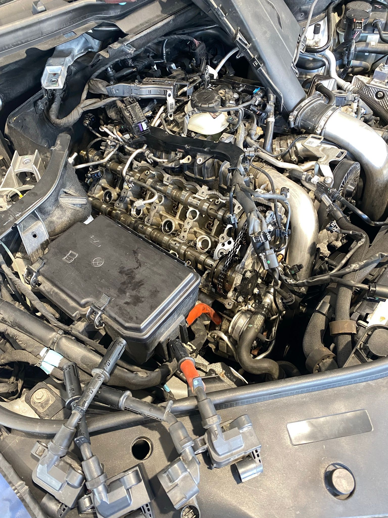 Un gros plan d'un moteur de voiture avec le capot ouvert.