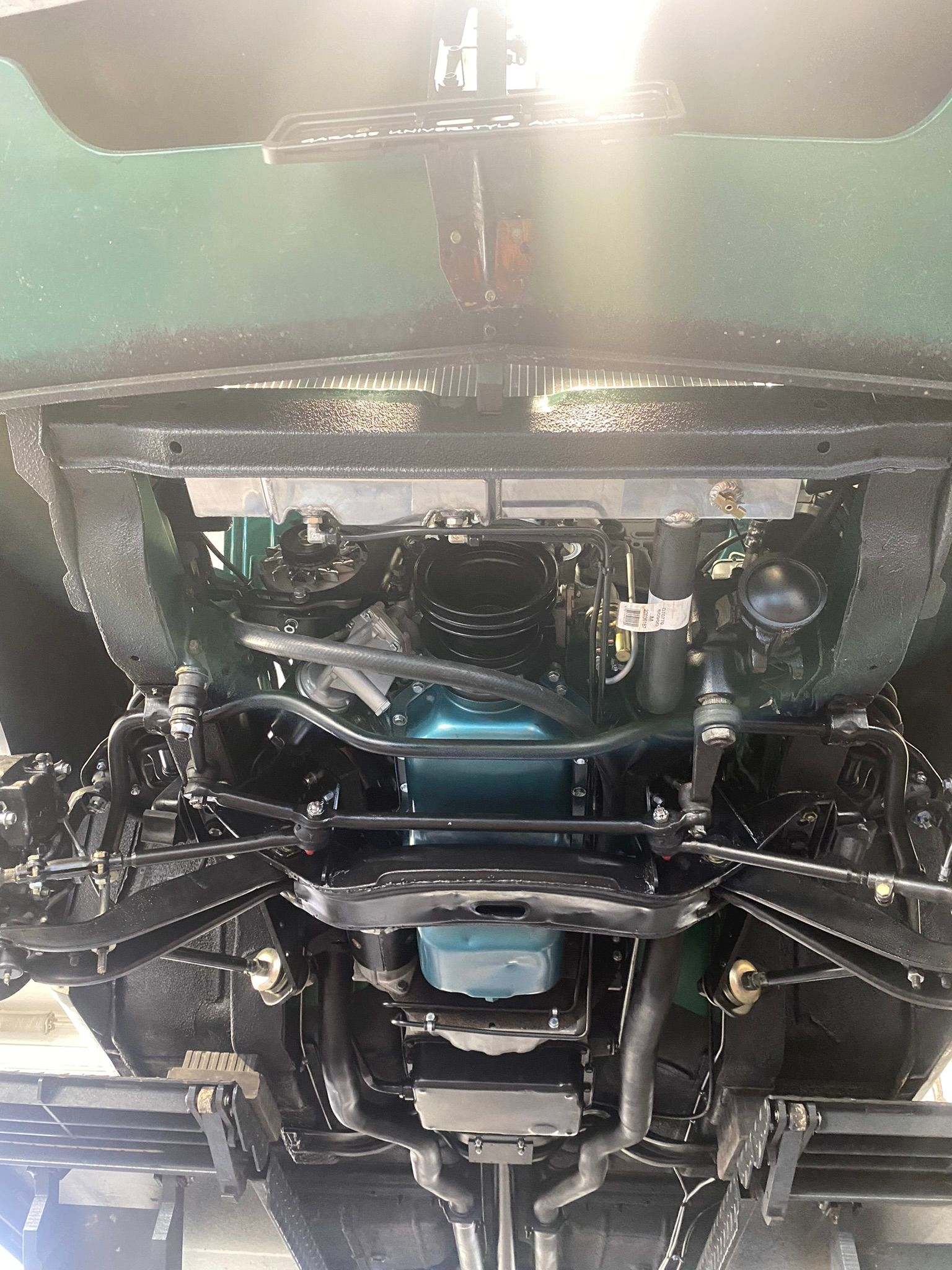 Un gros plan du dessous d’une voiture avec le moteur visible.