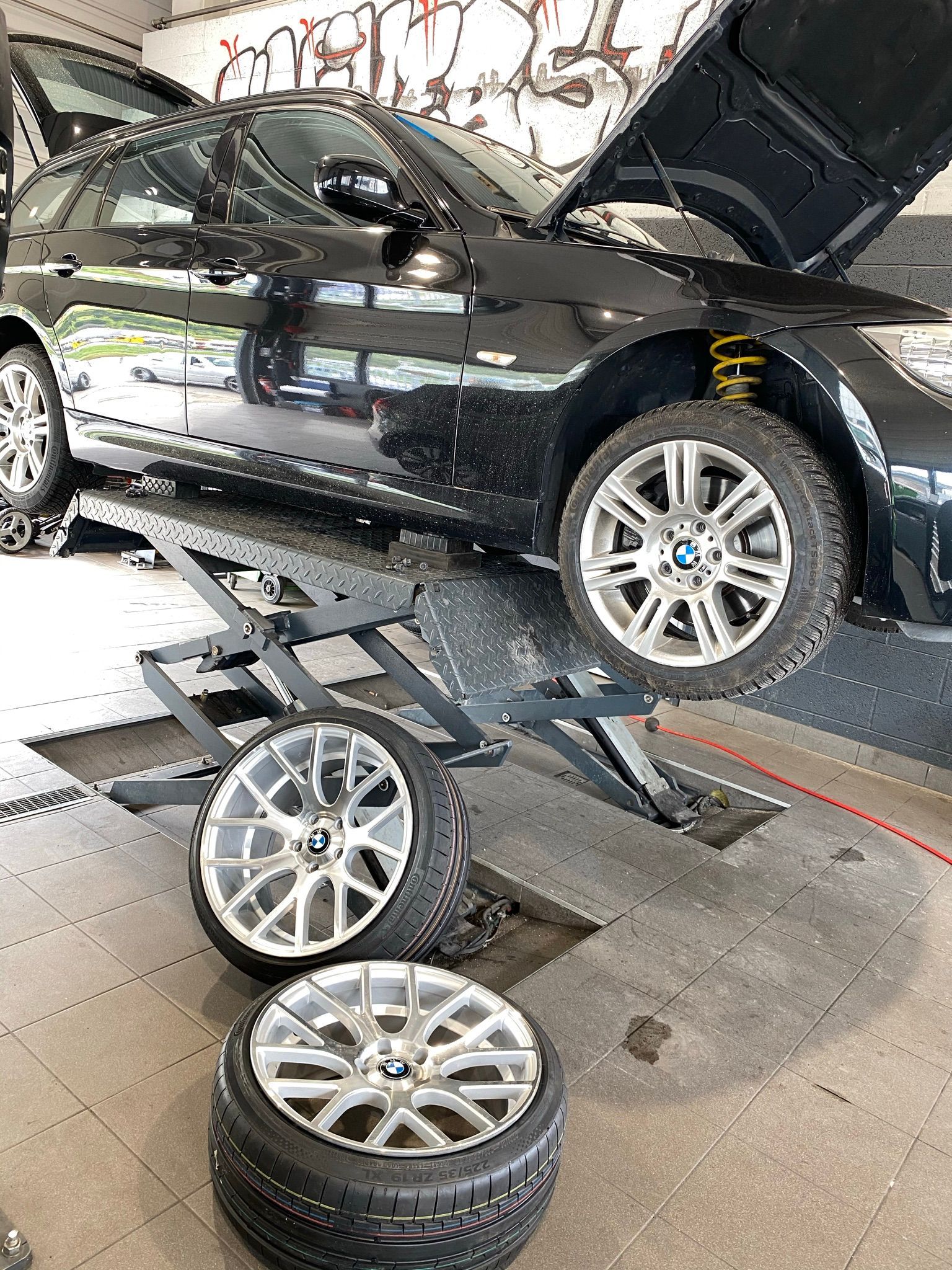 Une voiture est soulevée sur un ascenseur dans un garage.