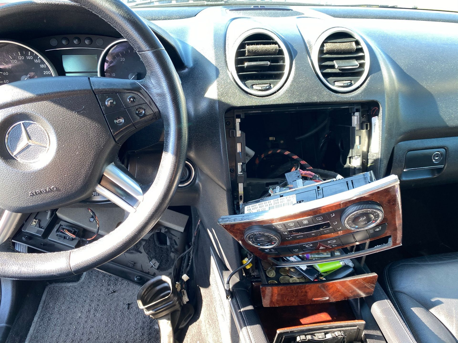 Le tableau de bord d'une Mercedes Benz avec l'unité de climatisation retirée.