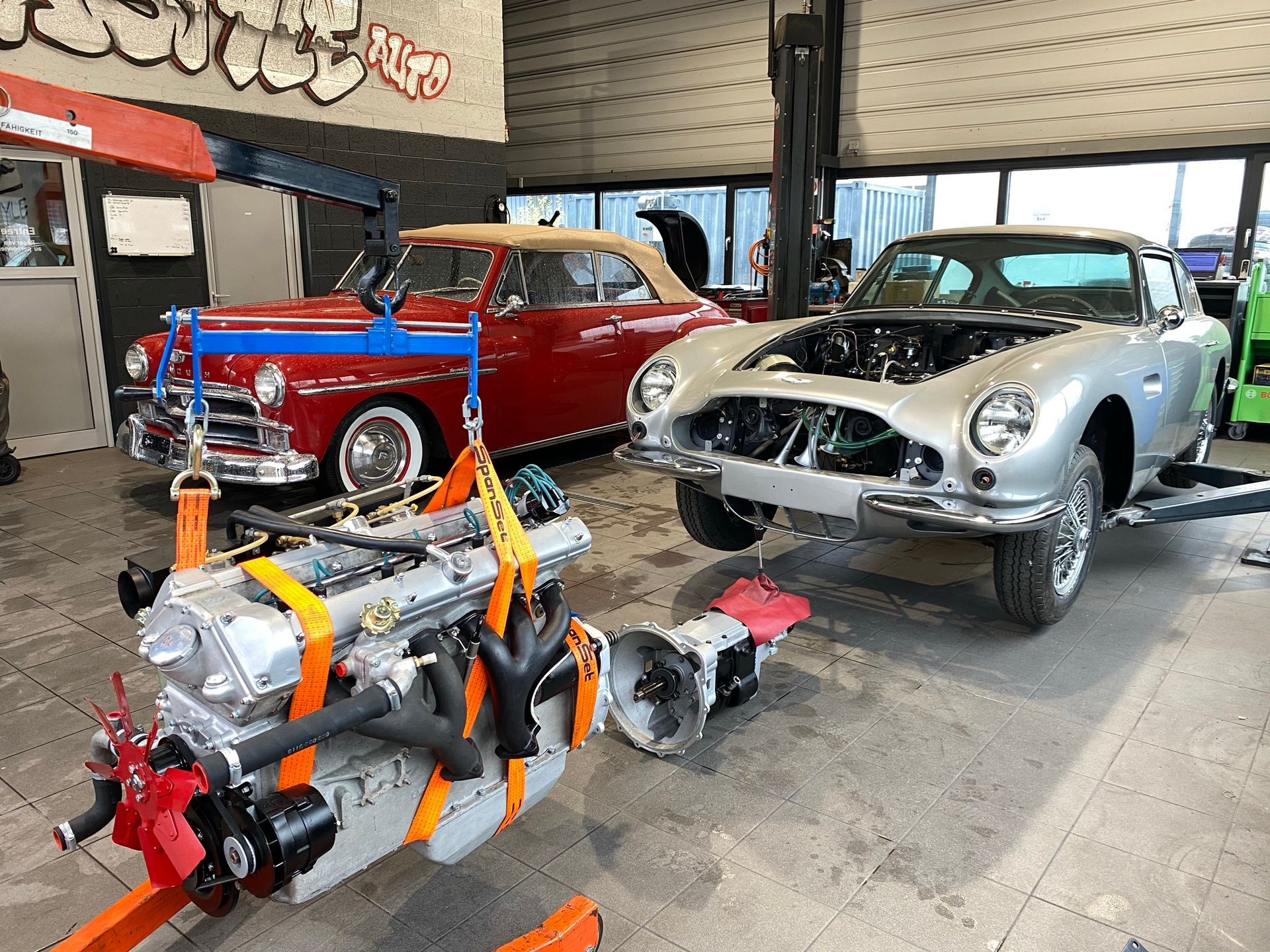 Un groupe de voitures est en cours de réparation dans un garage.