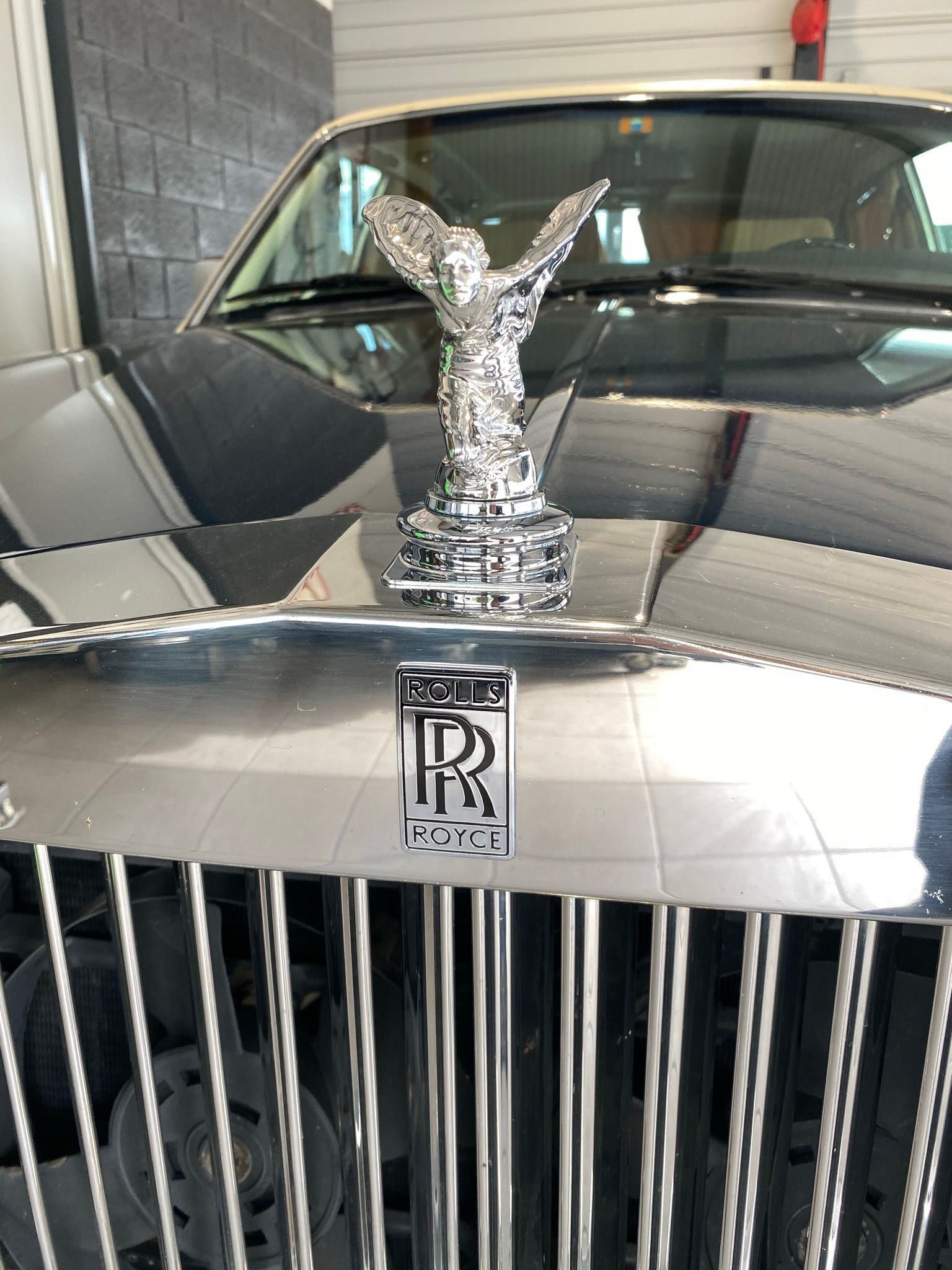 L'avant d'une voiture Rolls Royce avec une statue d'ange au-dessus.