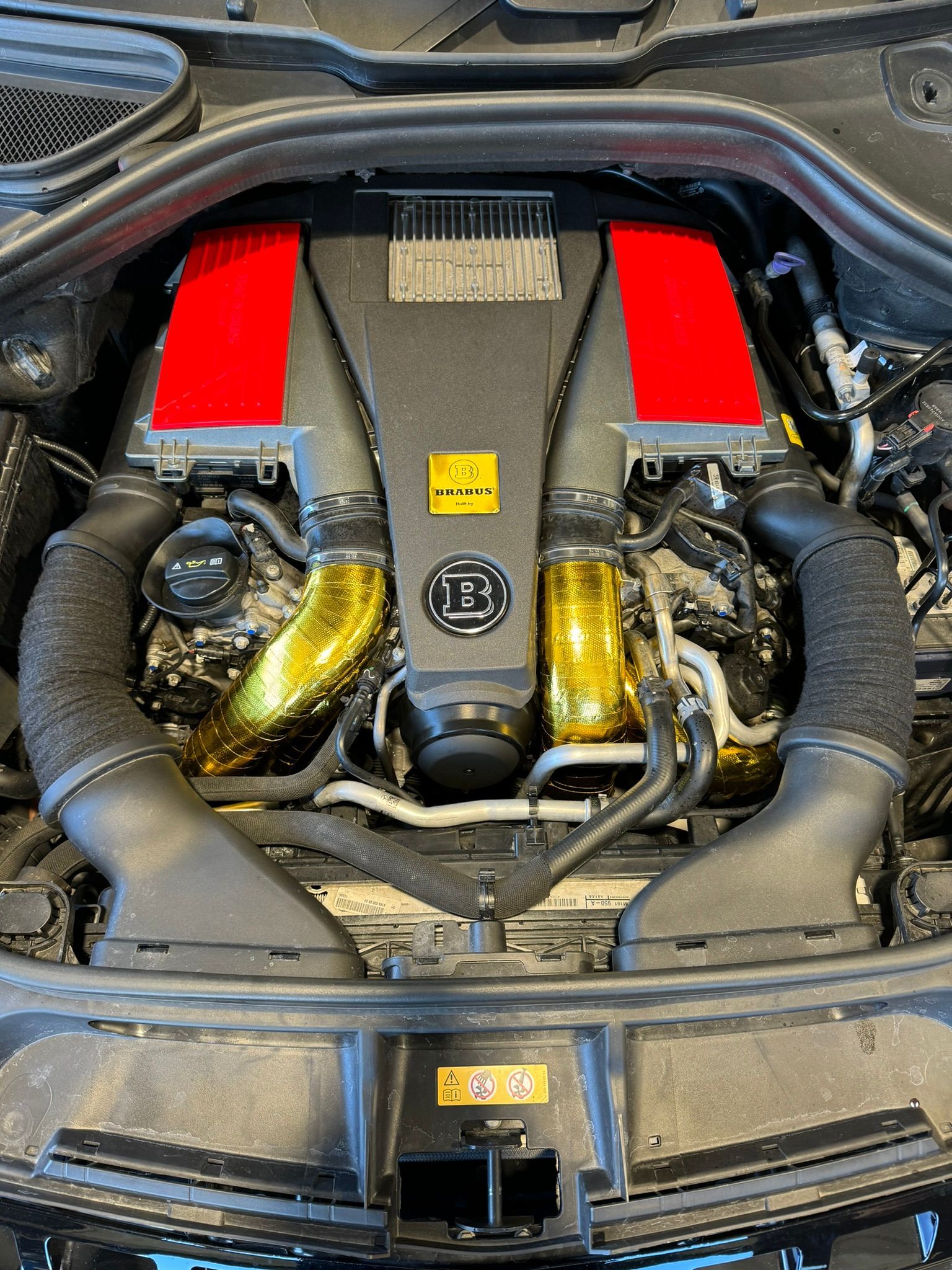 Un gros plan du moteur d’une voiture avec des tuyaux d’échappement rouges.