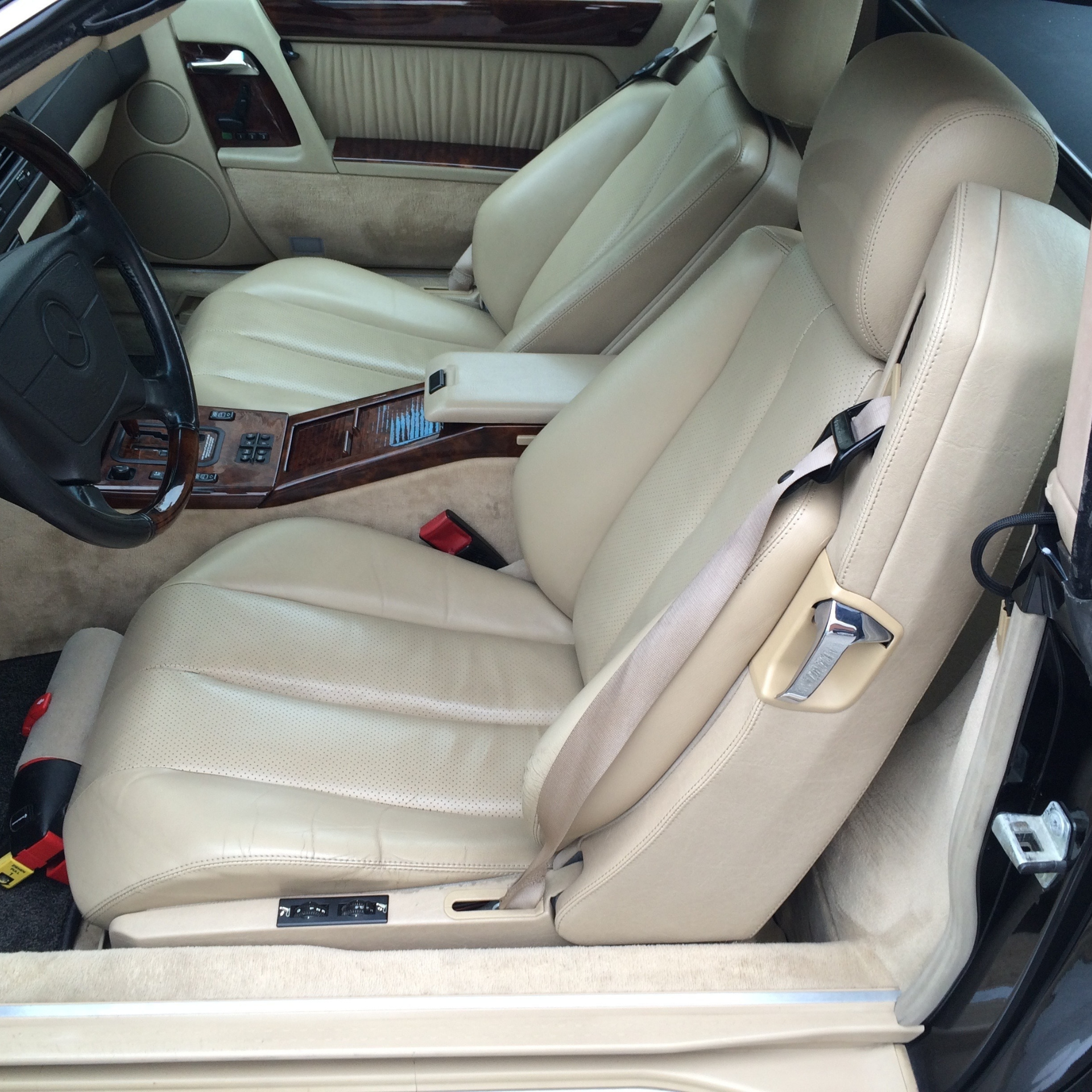 Une voiture noire avec des sièges en cuir beige et un volant