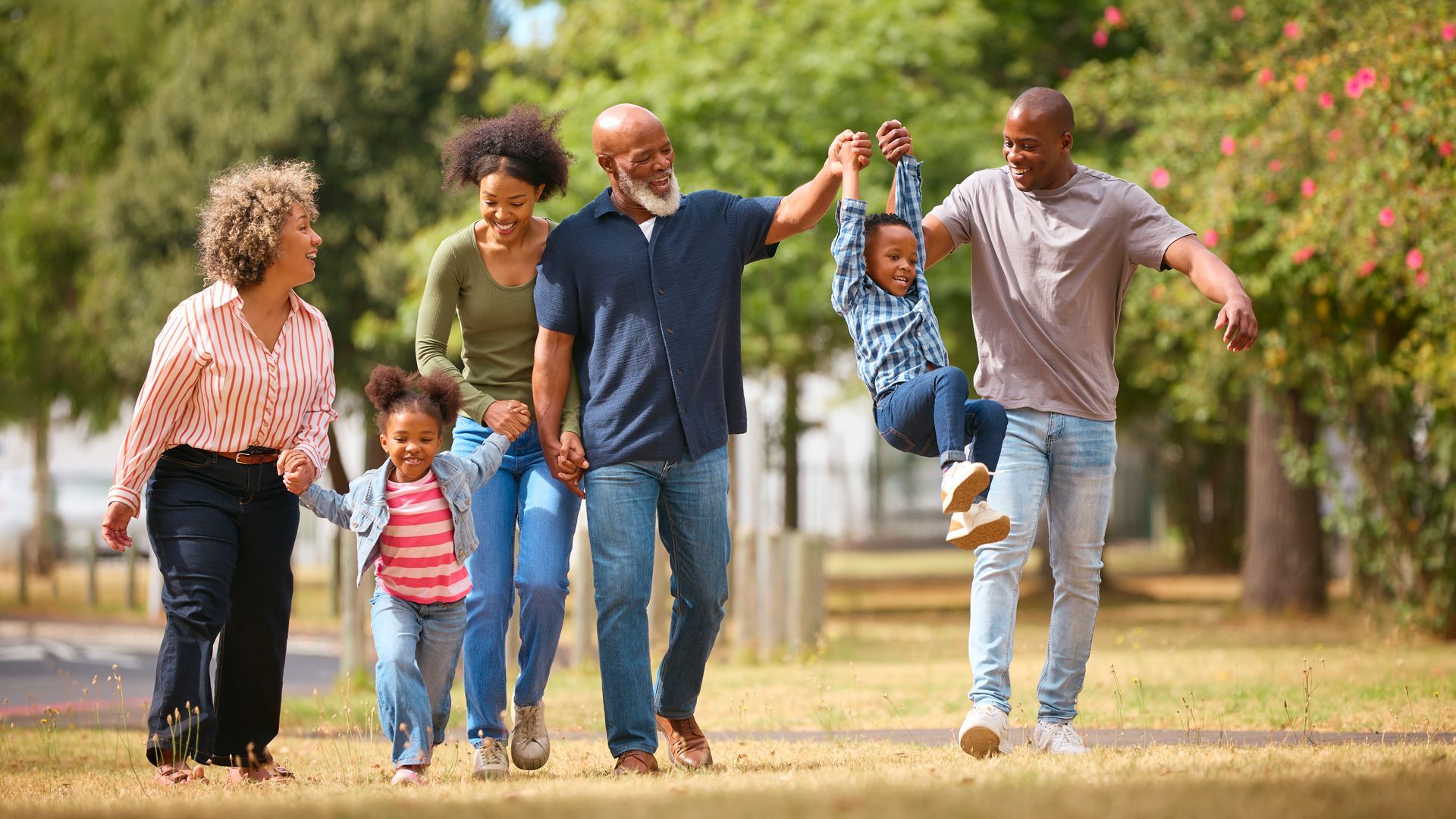Family of six walking outdoors, laughing and playing.