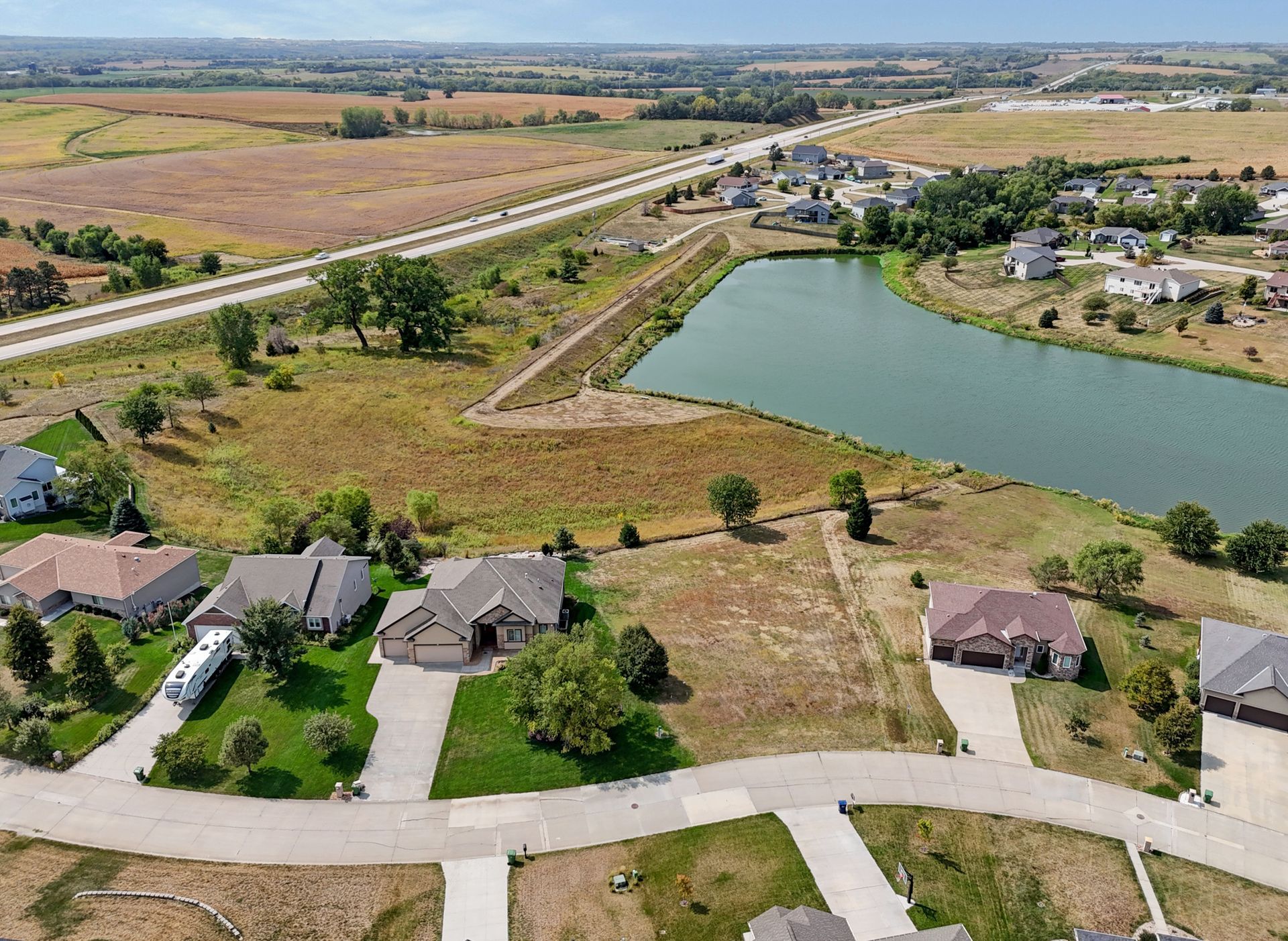 An aerial view of a residential area with a lake in the middle.