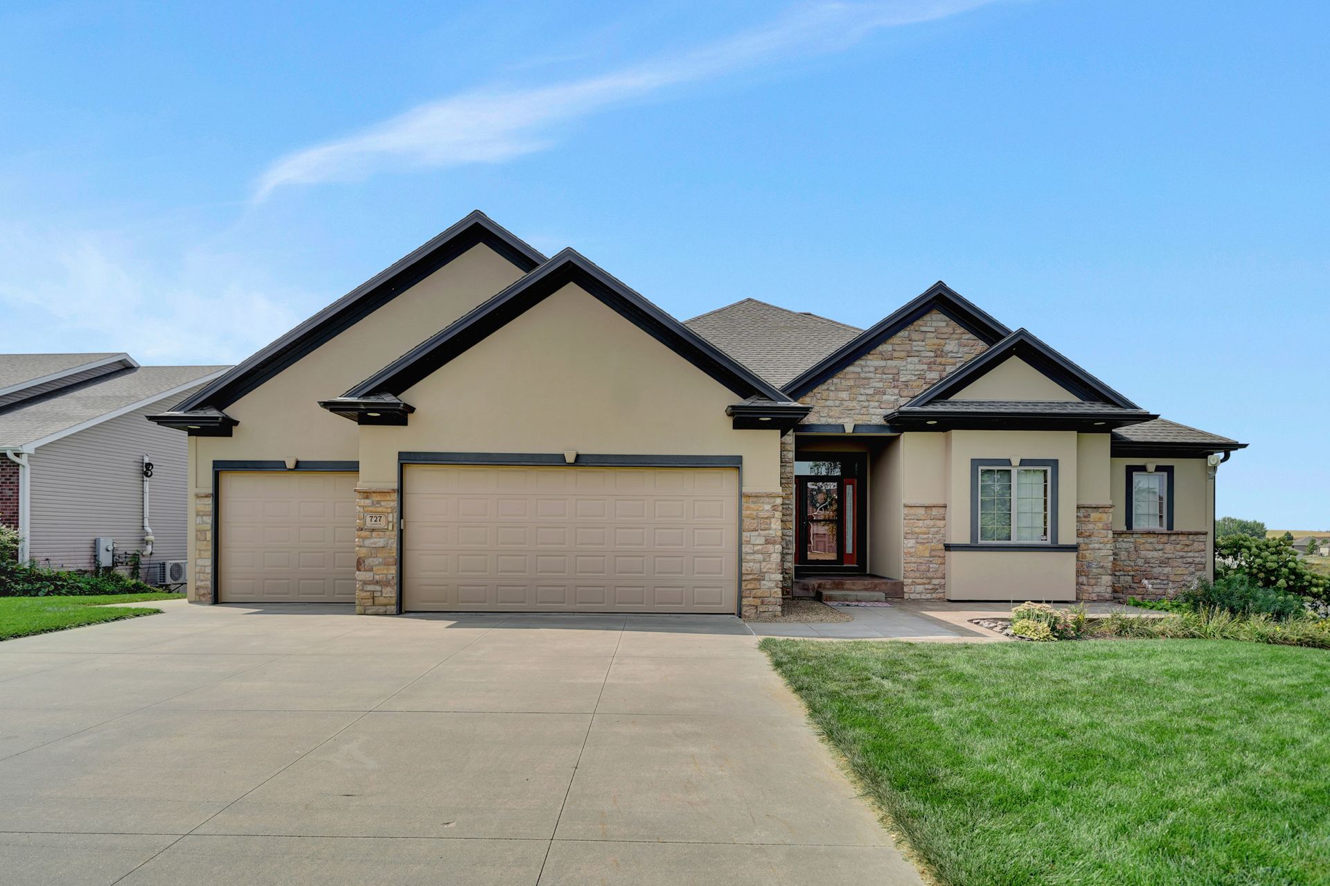 The front of a house with two garage doors and a driveway.