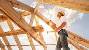 A man is standing on top of a wooden structure.