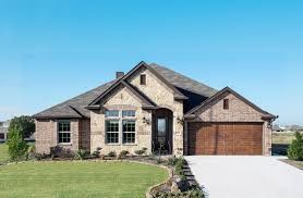 A large brick house with a large garage and a driveway.