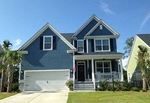 A large blue house with a white garage door and a porch.
