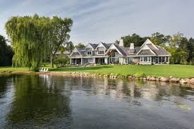 A large house is sitting next to a body of water.