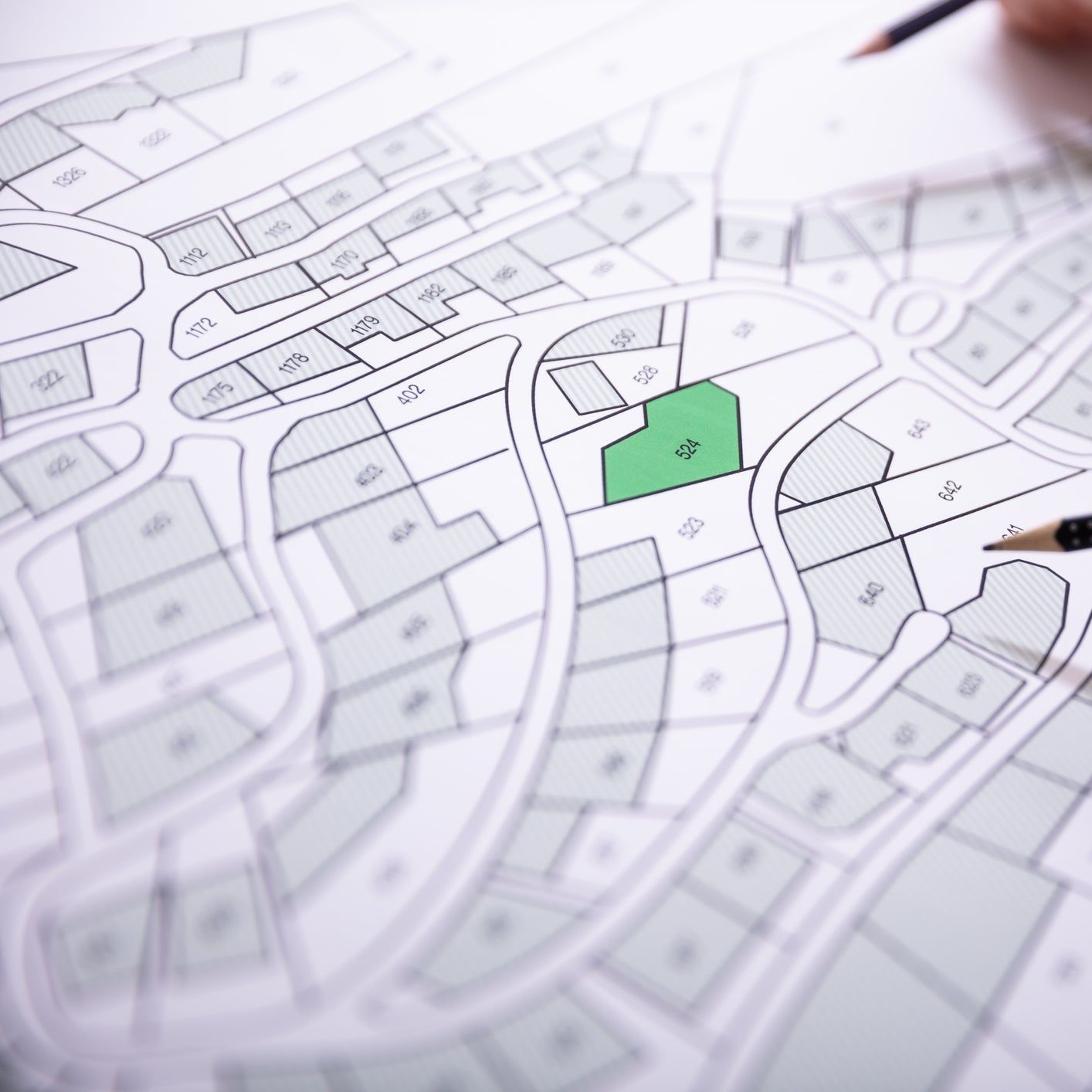 A person is drawing a map with a green square in the middle