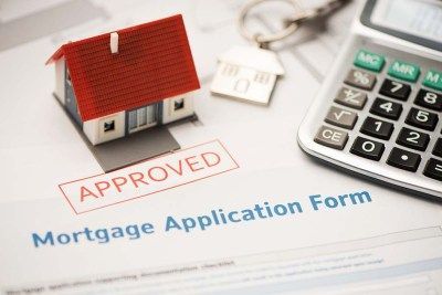 A mortgage application form with a house and a calculator on it.
