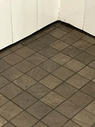 A close up of a tiled floor in a room with white walls.