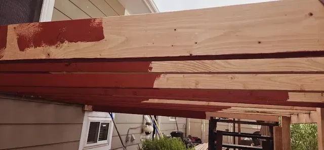 A wooden structure is being built on the side of a house.