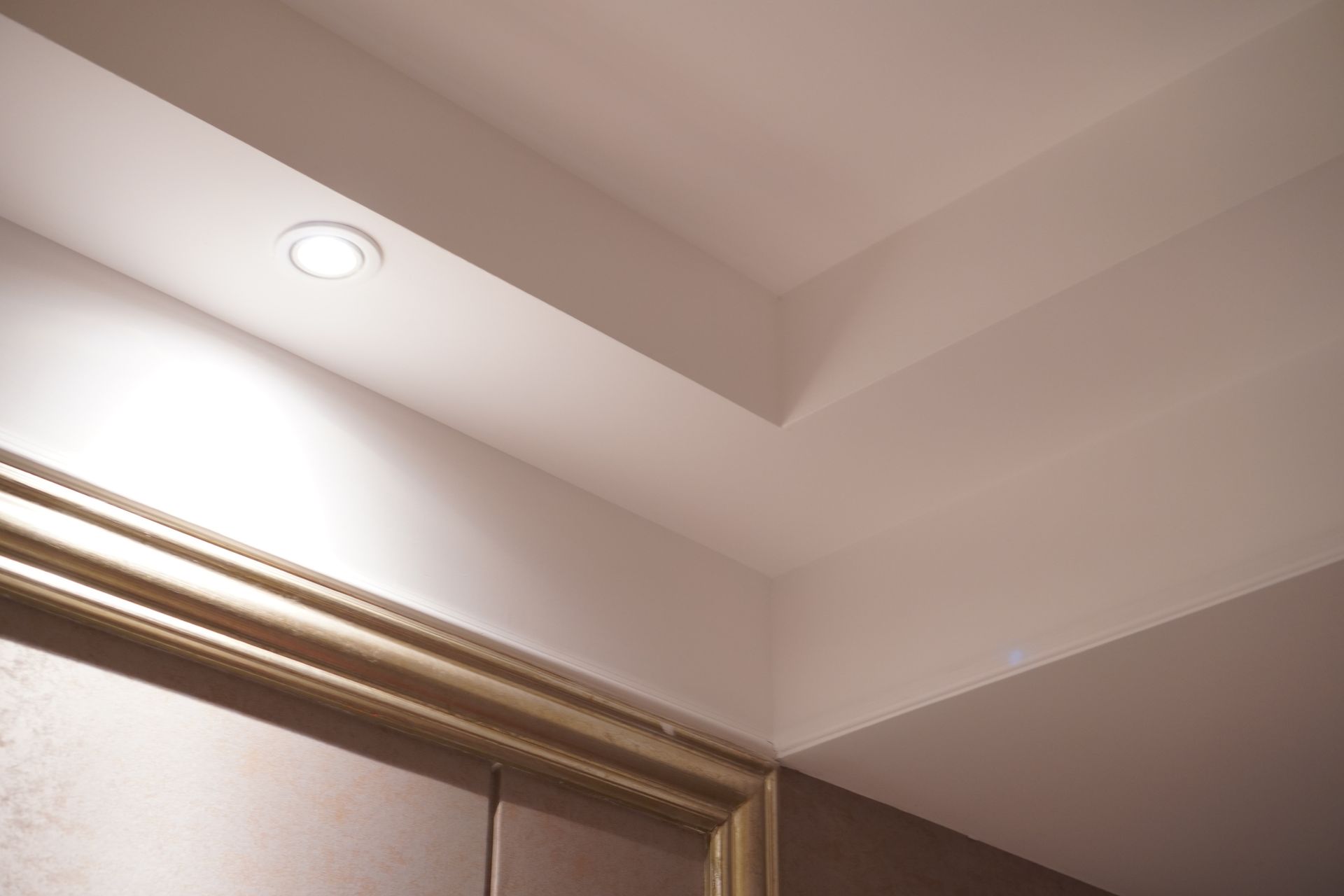 A ceiling with a light on it and a door in the background.