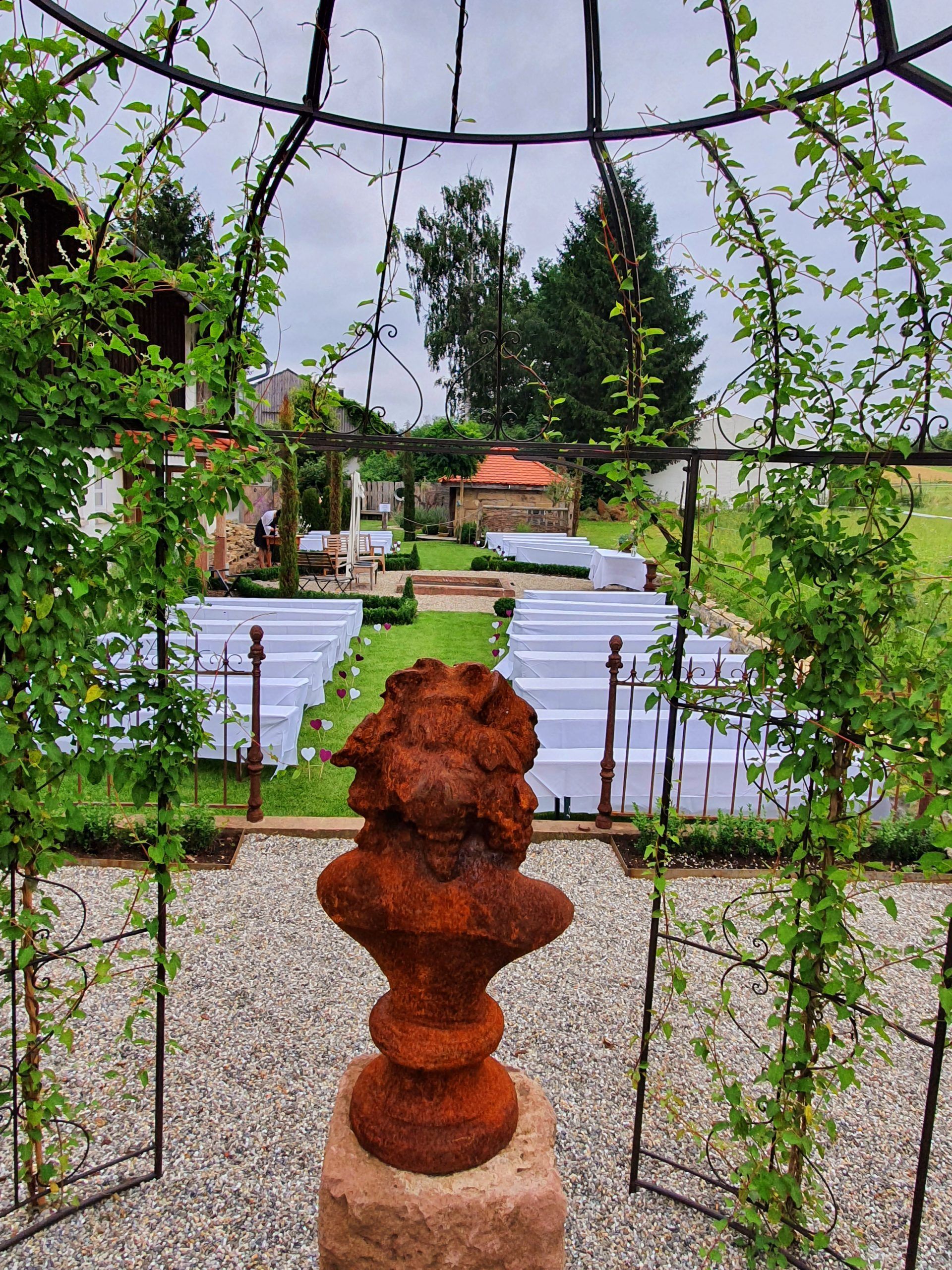 A statue of a lion is sitting in front of a gazebo.