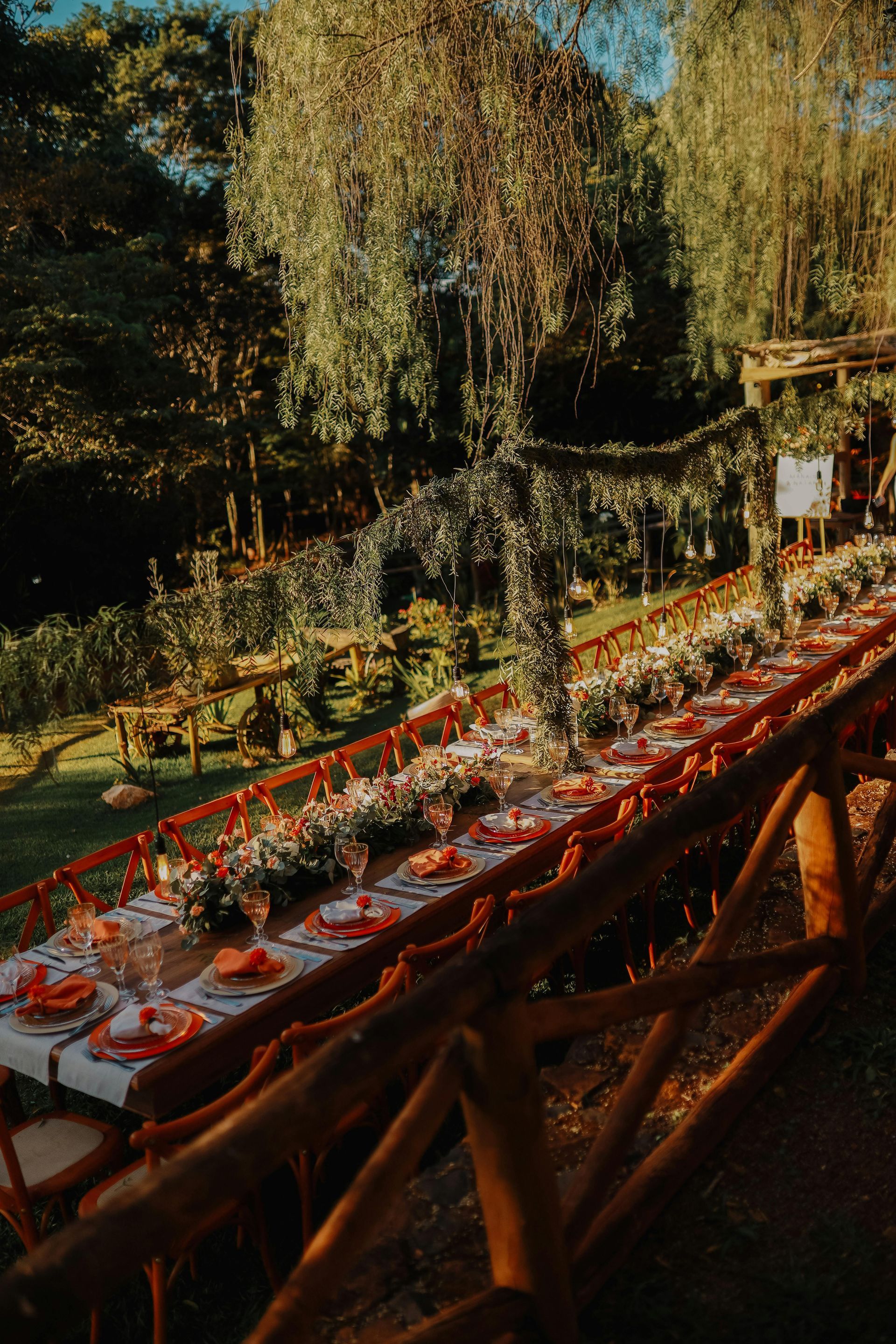 A long table set for a wedding reception in the woods.