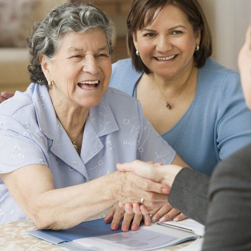 Senior Hispanic woman shaking hands with businesswoman