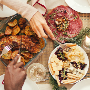 Overhead view of a group of people sitting around a festive dinner table filled with various dishes and drinks.