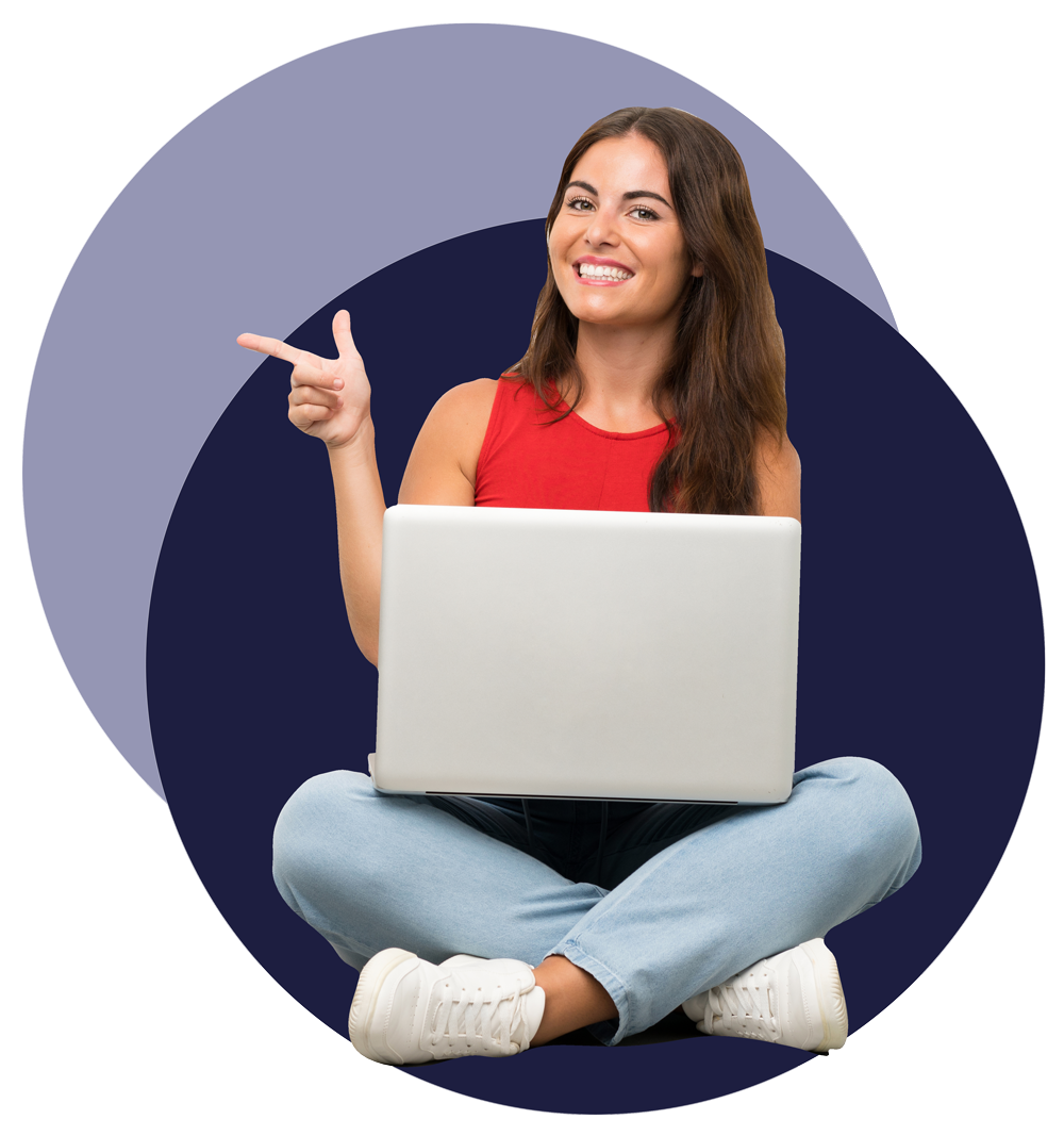 Woman smiling and sitting down with a laptop on her legs and she is pointing with her hand.