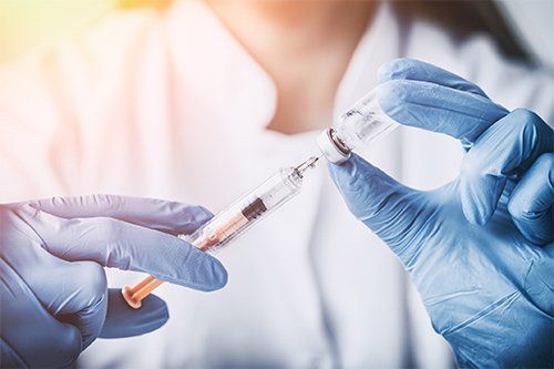 Physician Holding Injection And Vaccine — Memphis, TN — Vaccine Injury Lawyers