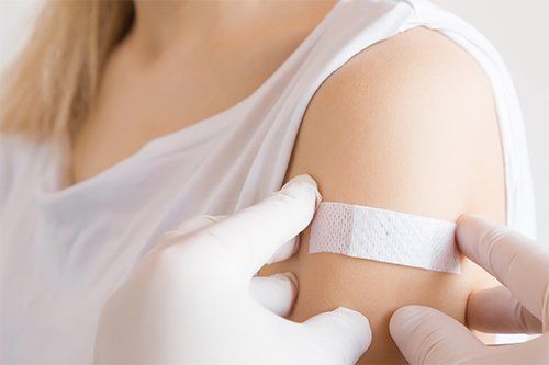 Putting Bandage On Woman's Shoulder — Memphis, TN — Vaccine Injury Lawyers